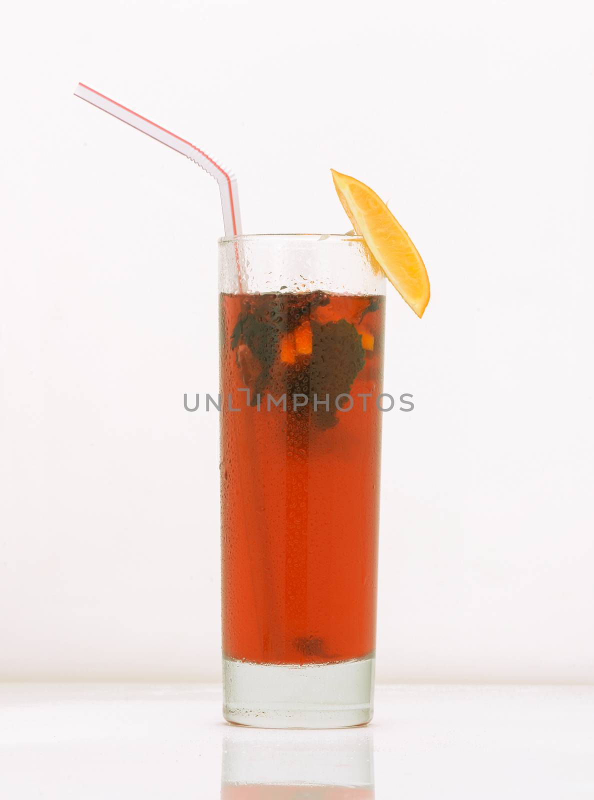 grapefruit tea in a glass with ice and straw. drink isolated on white background