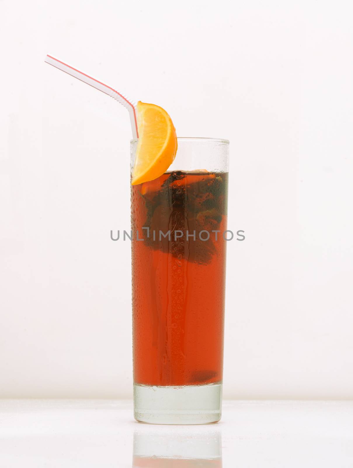 grapefruit tea in a glass with ice and straw. drink isolated on white background
