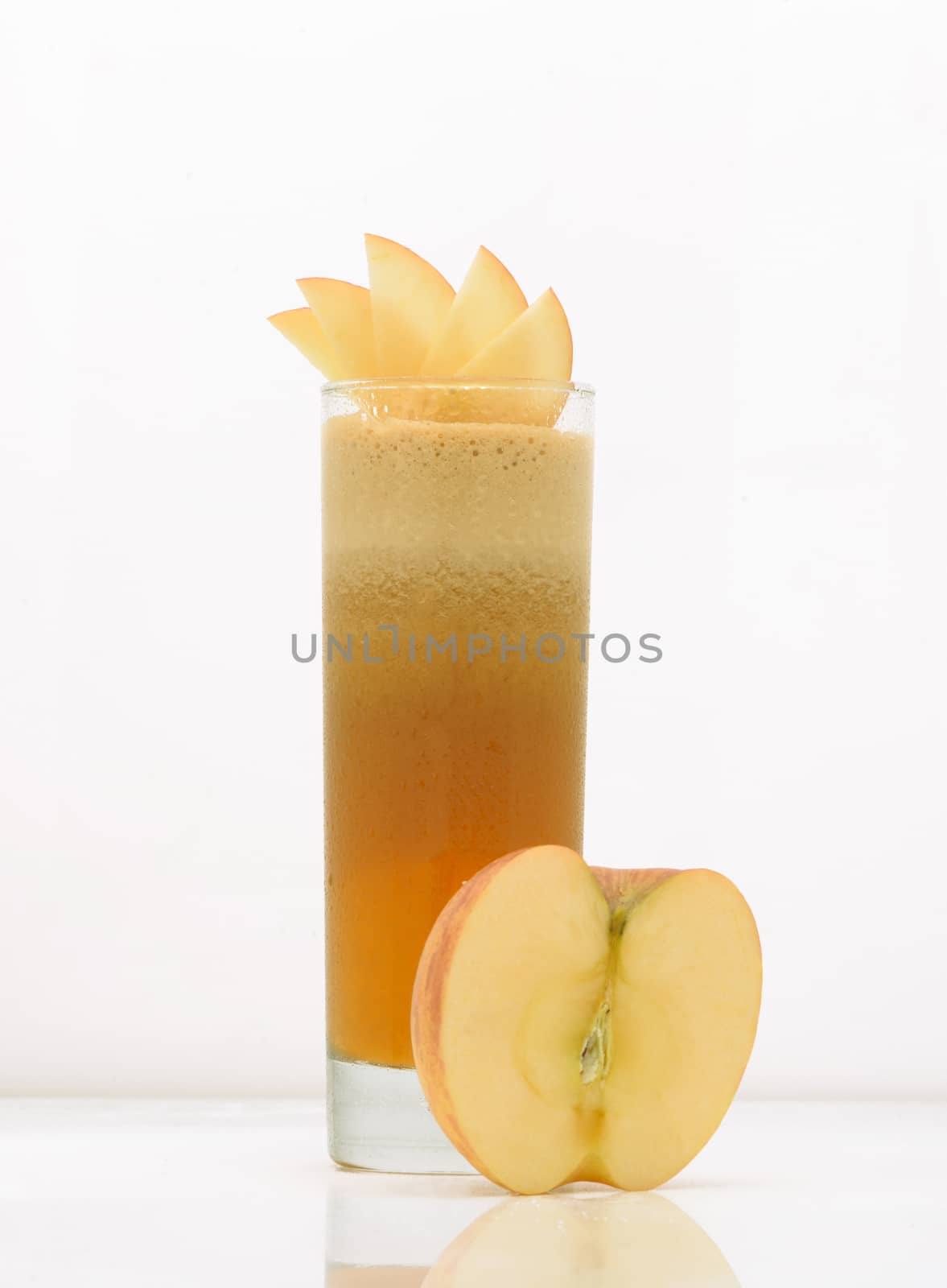 apple juice in a glass with ice and half apple. drink isolated on white background
