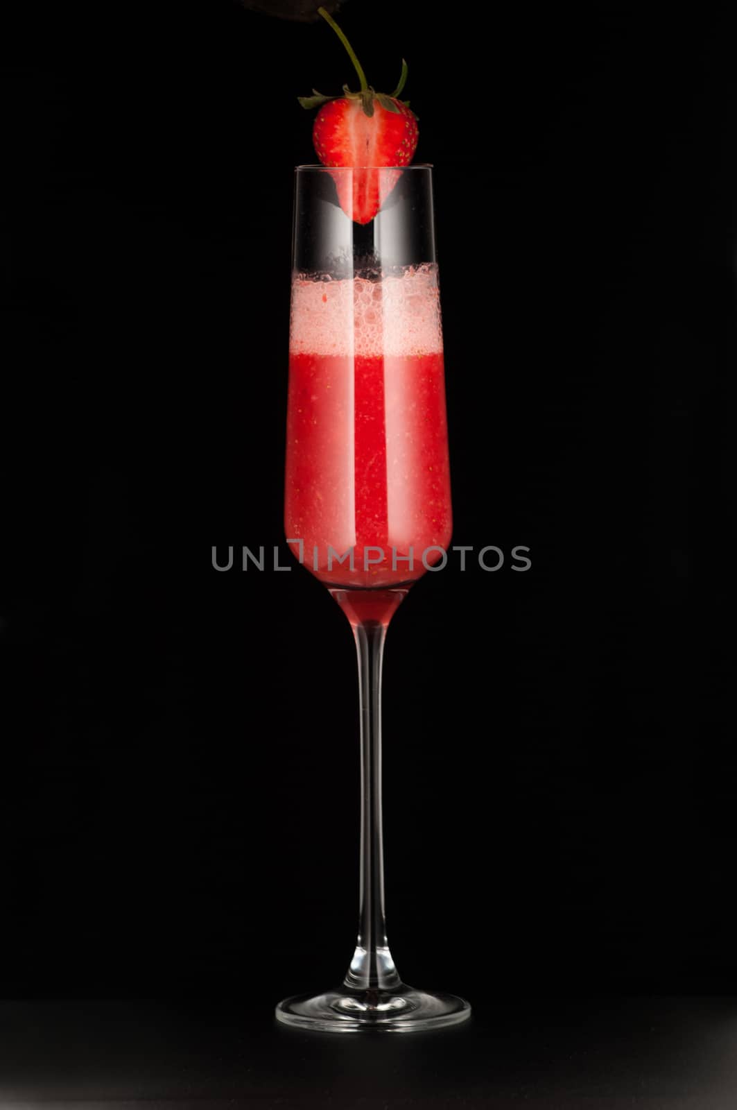 one glass cup with strawberry drink and strawberries on dark background