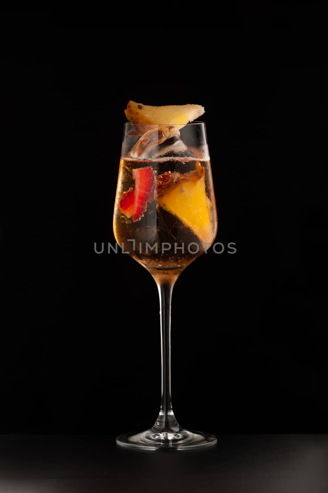 one glass beaker with a fruity drink on a dark background