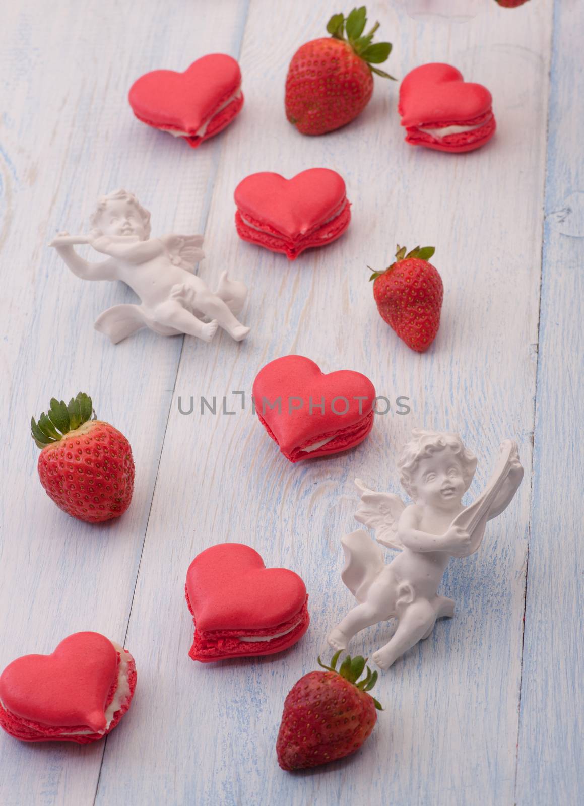 cookies red heart shaped strawberries and decorated with angel on the wooden boards on Valentine's Day