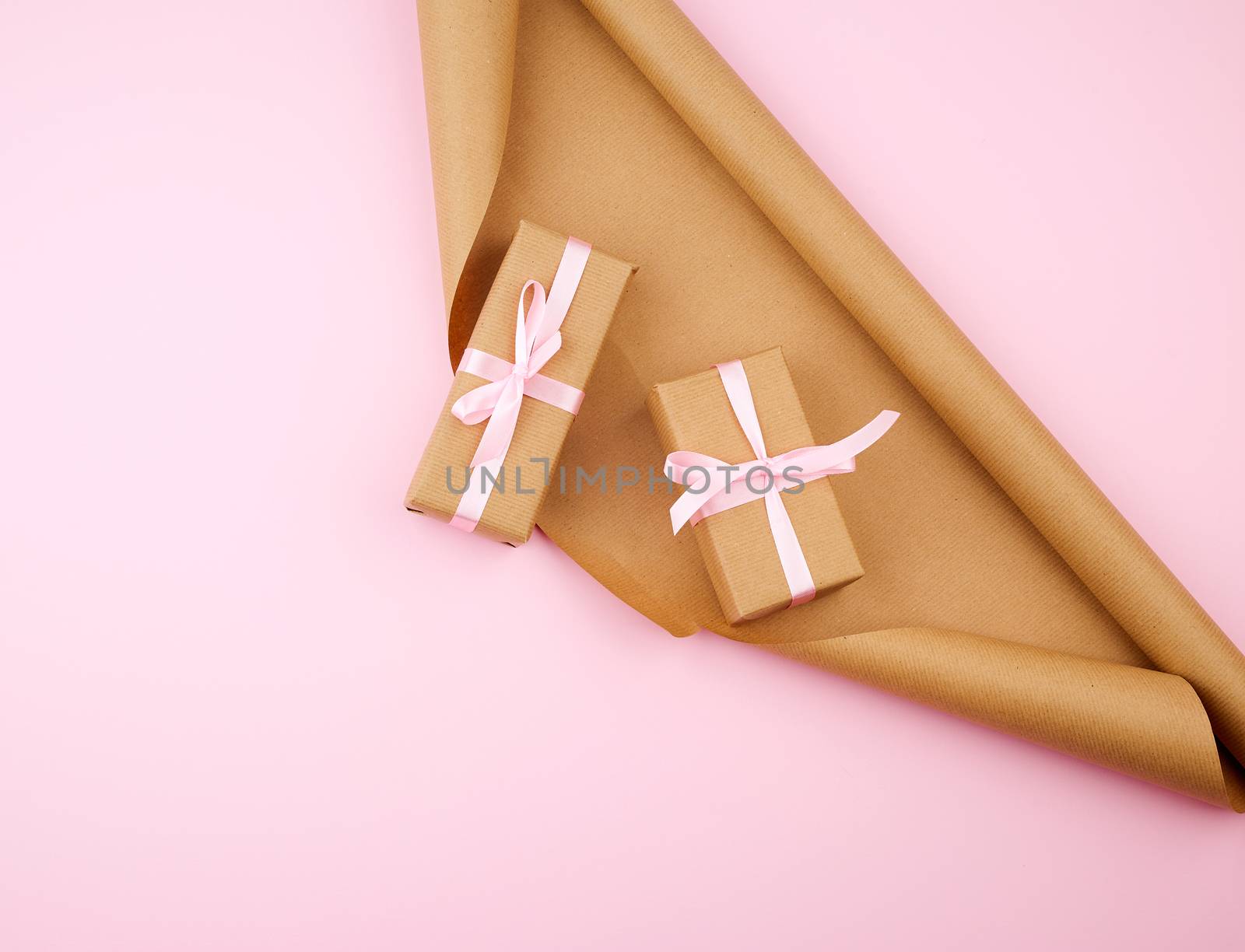 brown kraft paper, packed gift boxes and tied with a pink ribbon, set of items for making gifts. Package design, copy space