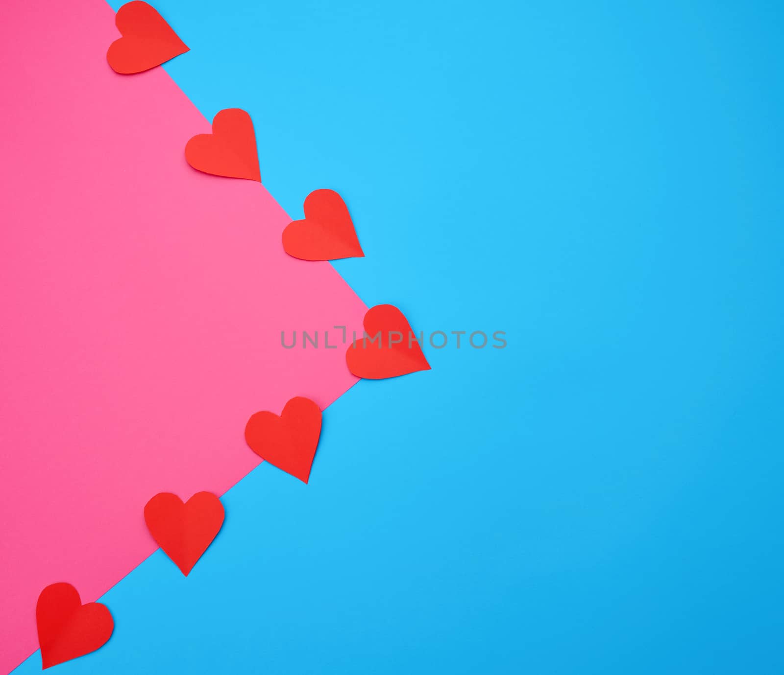 hearts cut out of red paper on a blue pink background, festive backdrop for Valentine's Day, flat lay, copy space
