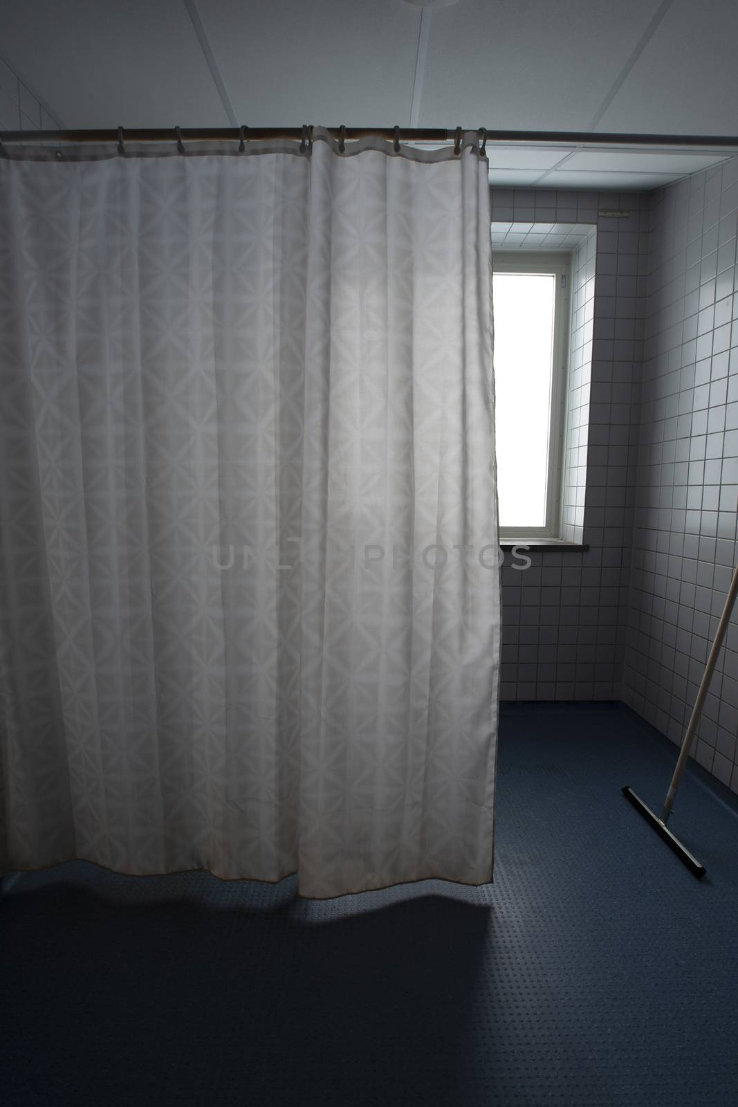 Bathroom with old shower curtain in hospital.