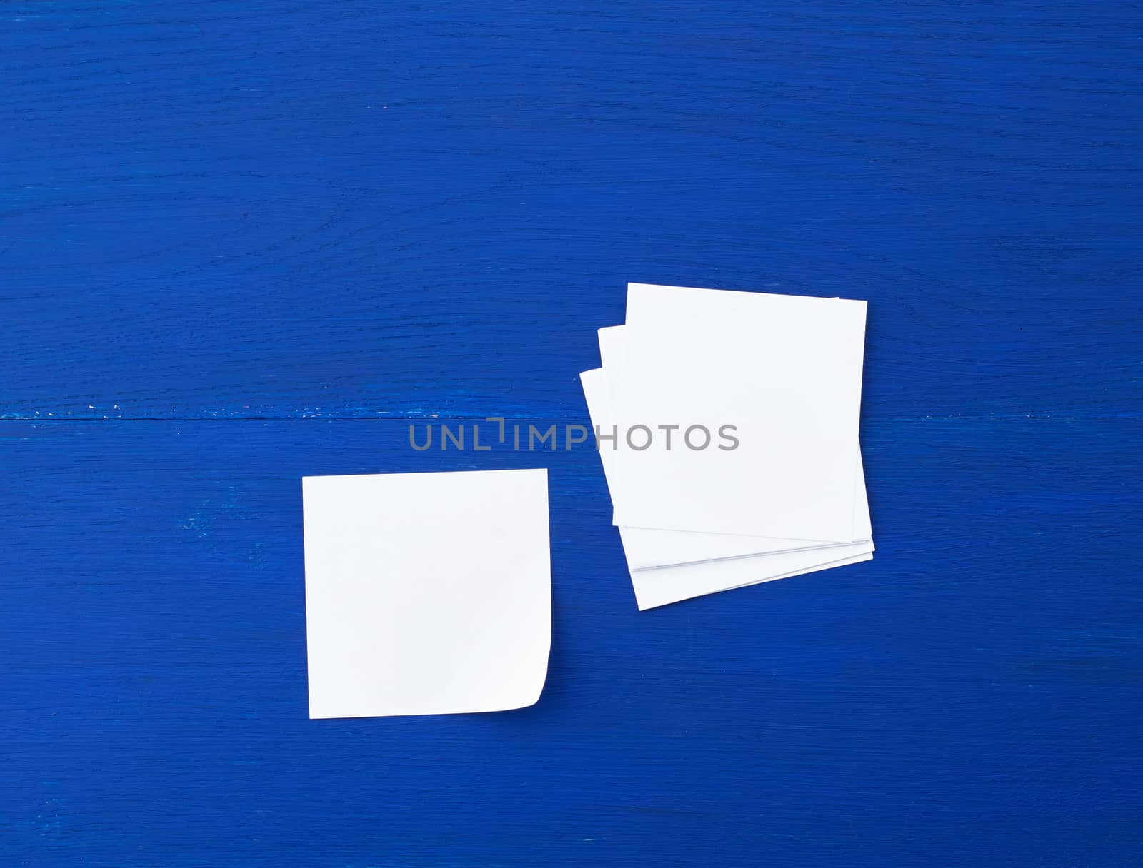 empty white sheet of paper on a blue wooden background, copy space