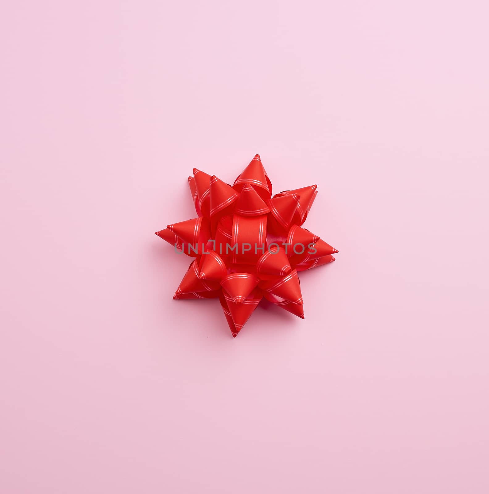 big red beautiful bow on a pink background, a festive element for the designer, copy space