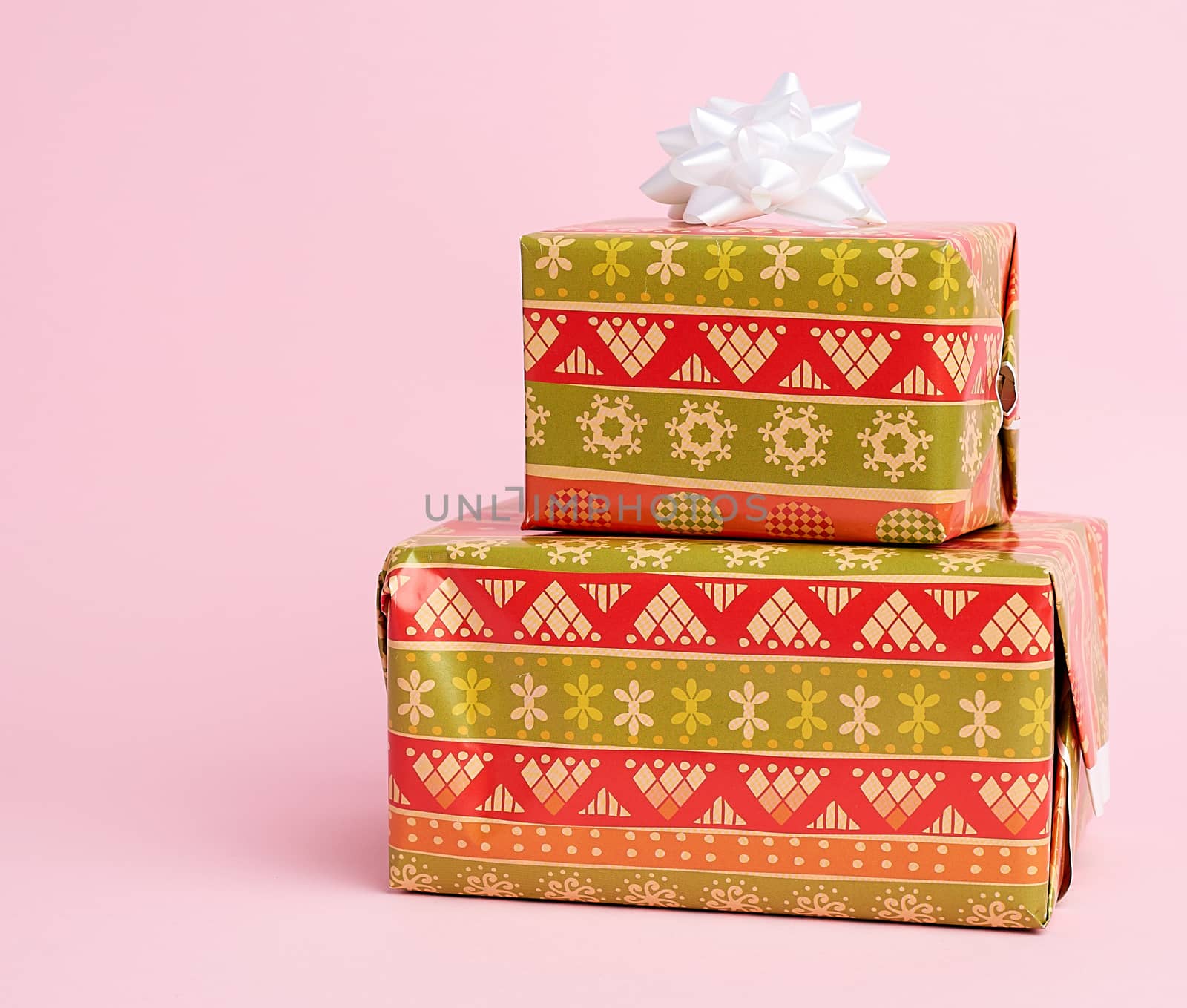 stack of colored paper wrapped gift boxes. great design for any purposes, pink background 