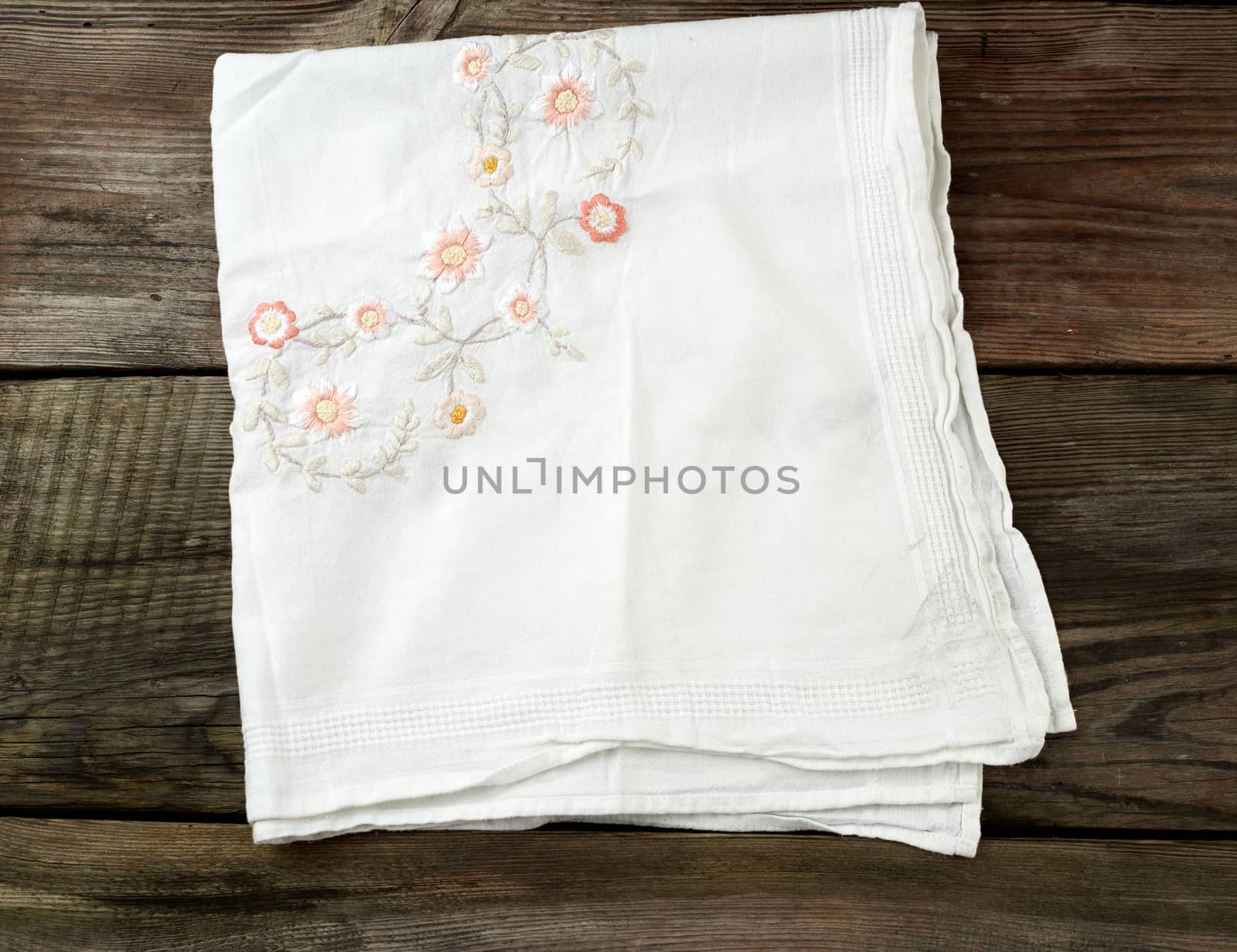 white kitchen textile towel folded on a gray wooden table from old boards, top view, empty space. Rustic texture. Retro background