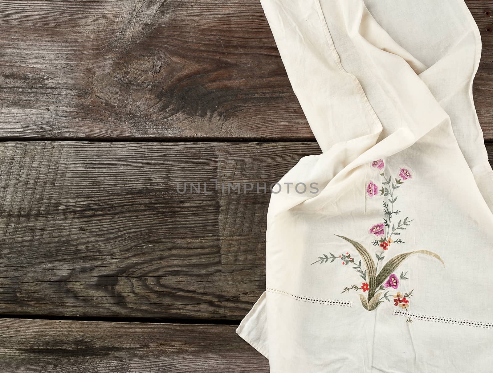 white kitchen textile towel folded on a gray wooden table from old boards, top view, empty space. Rustic texture. Retro background