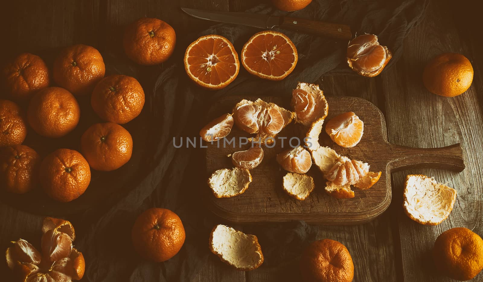 ripe round tangerines and cut in half on an old vintage cutting board. Healthy vegetarian food. Citrus fruit, top view