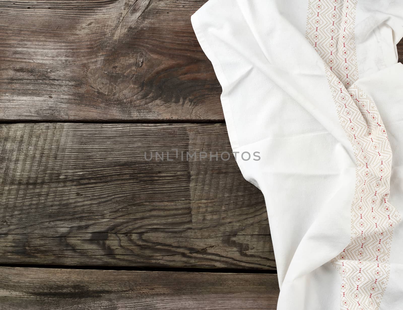 white kitchen textile towel folded on a gray wooden table from old boards, top view, empty space. Rustic texture. Retro background