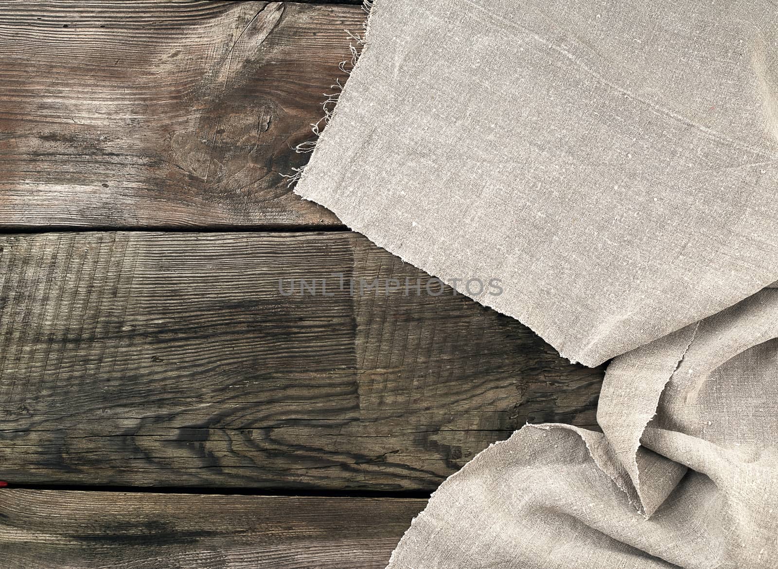 gray kitchen textile towel folded on a gray wooden table from old boards, top view, empty space. Rustic texture. Retro background