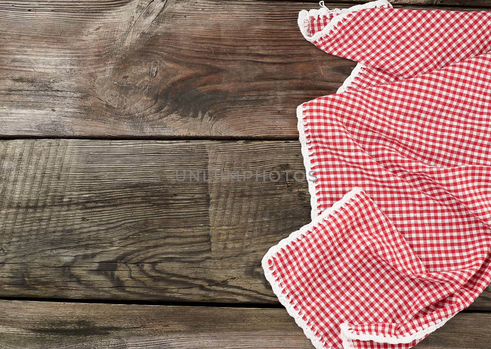 red-white textile kitchen towel on a wooden background from old gray boards, place for an inscription