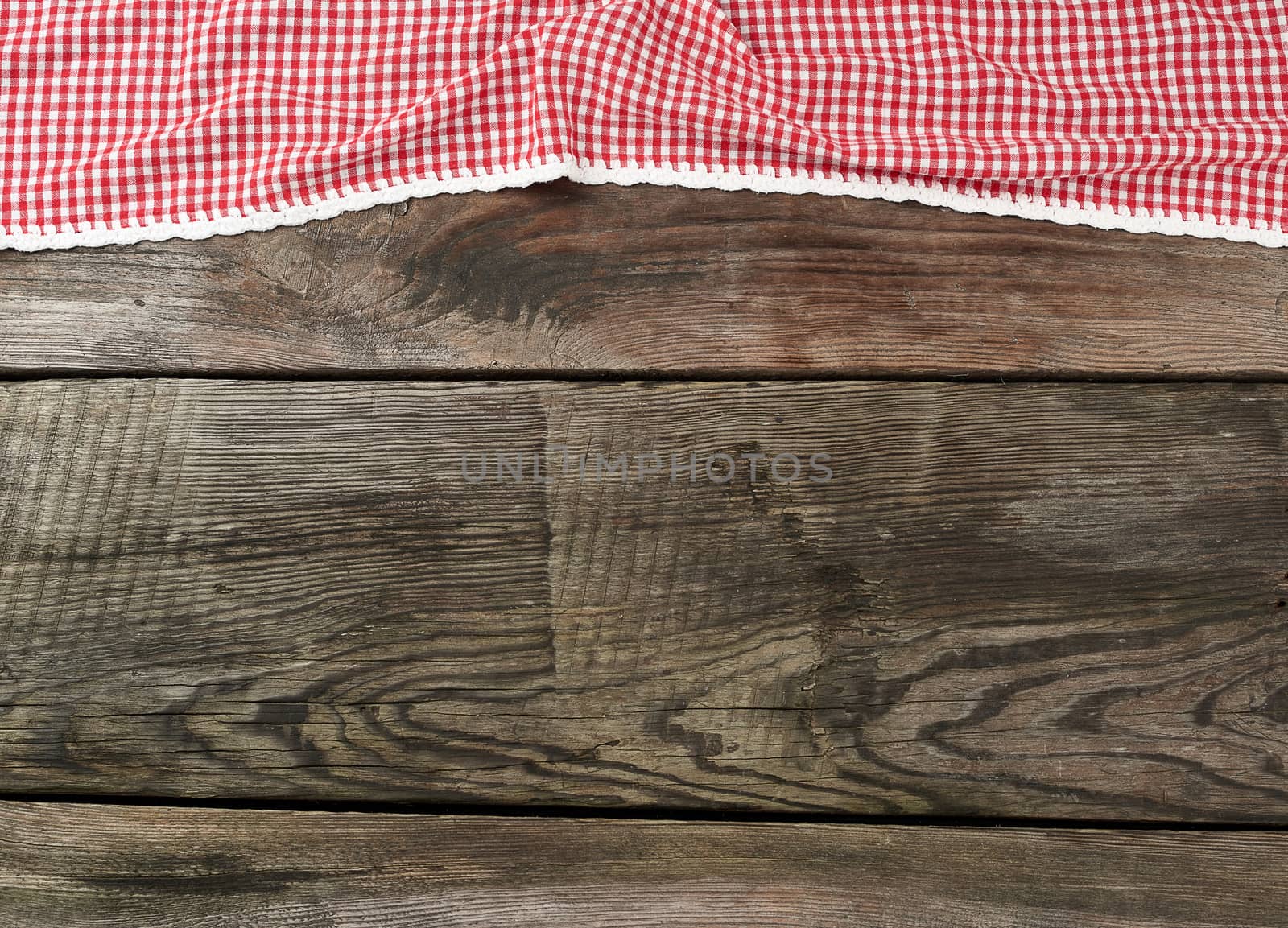red-white textile kitchen towel on a wooden background from old gray boards, place for an inscription