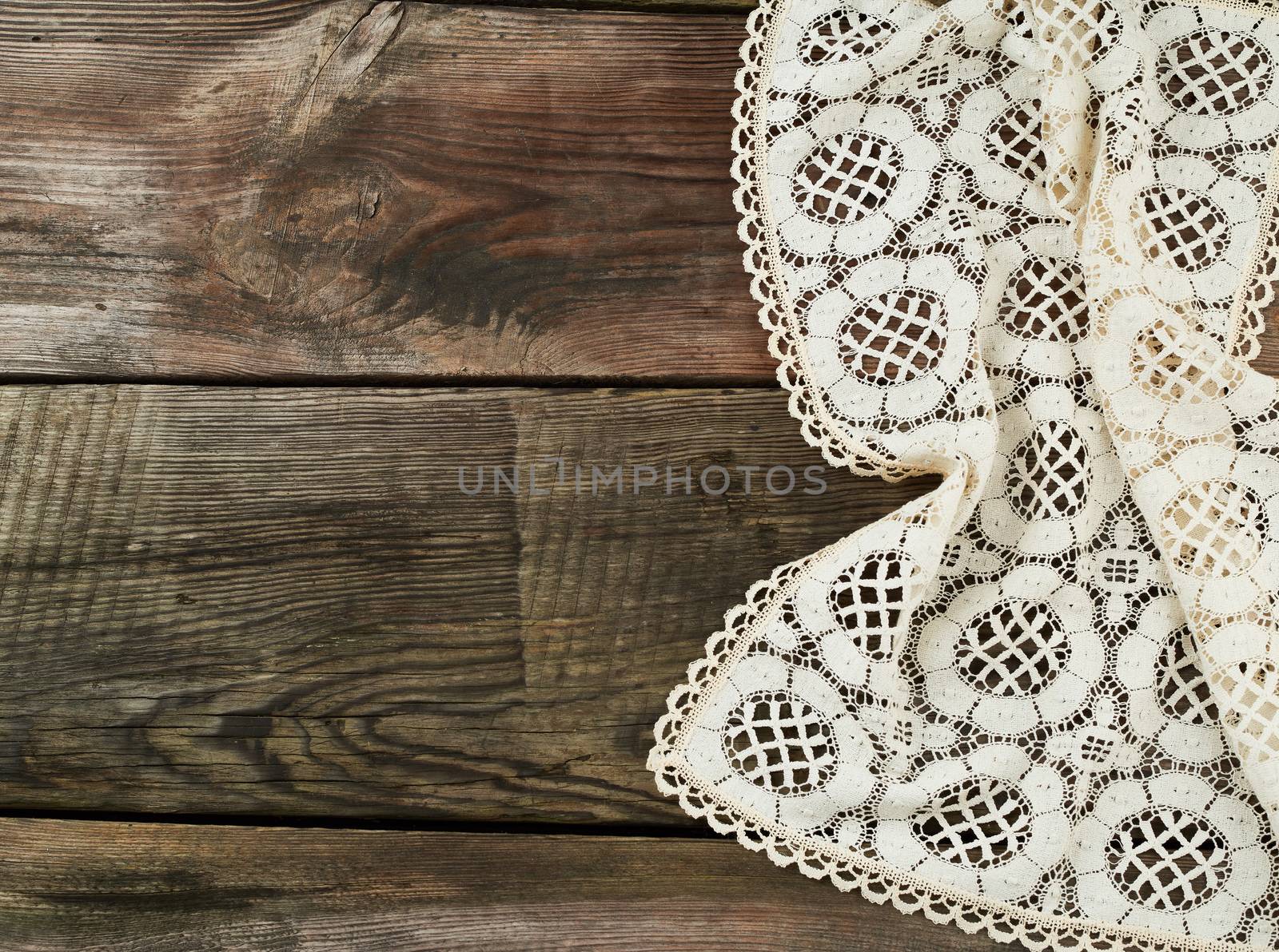 white kitchen textile lace towel folded on a gray wooden table from old boards, top view, empty space