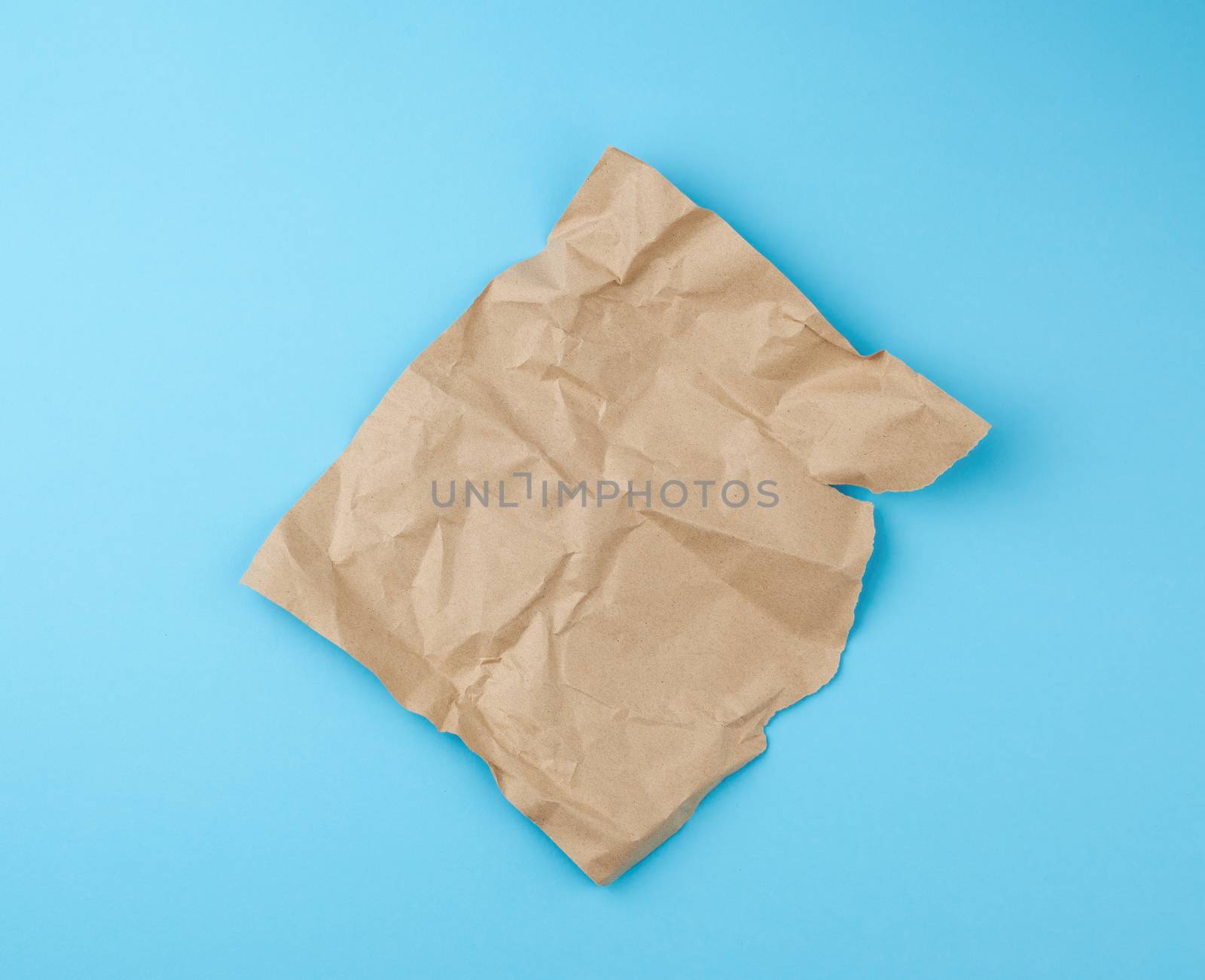 sheet of brown craft paper for packaging on a blue background, close up