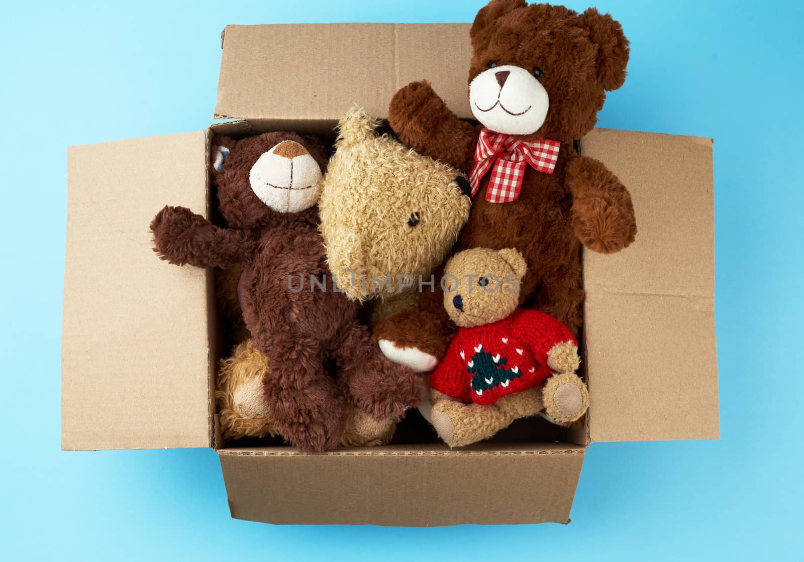 brown cardboard box with various teddy bears, top view, concept of assistance and volunteering