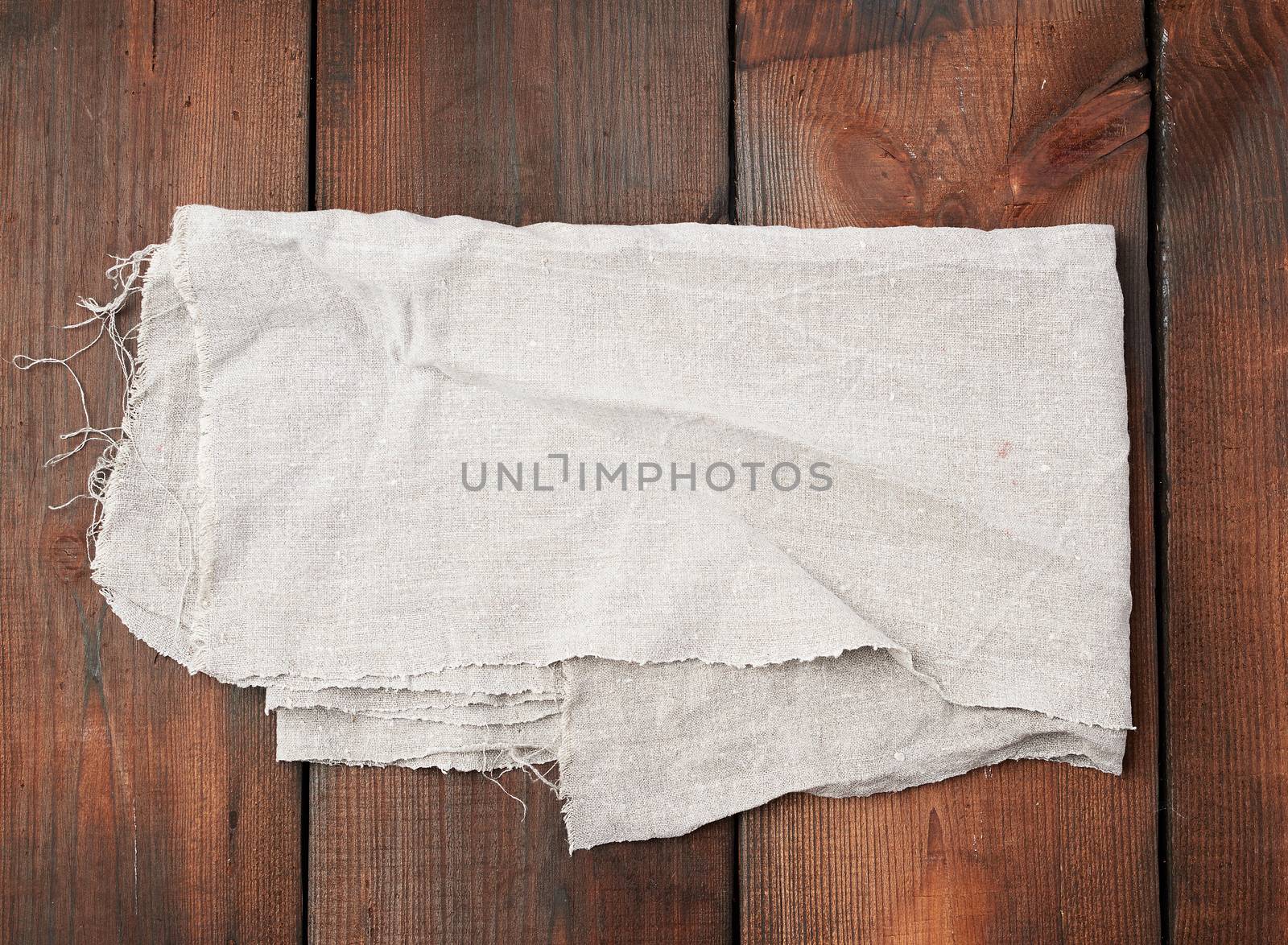 folded gray linen towel on wooden background, top view, copy space