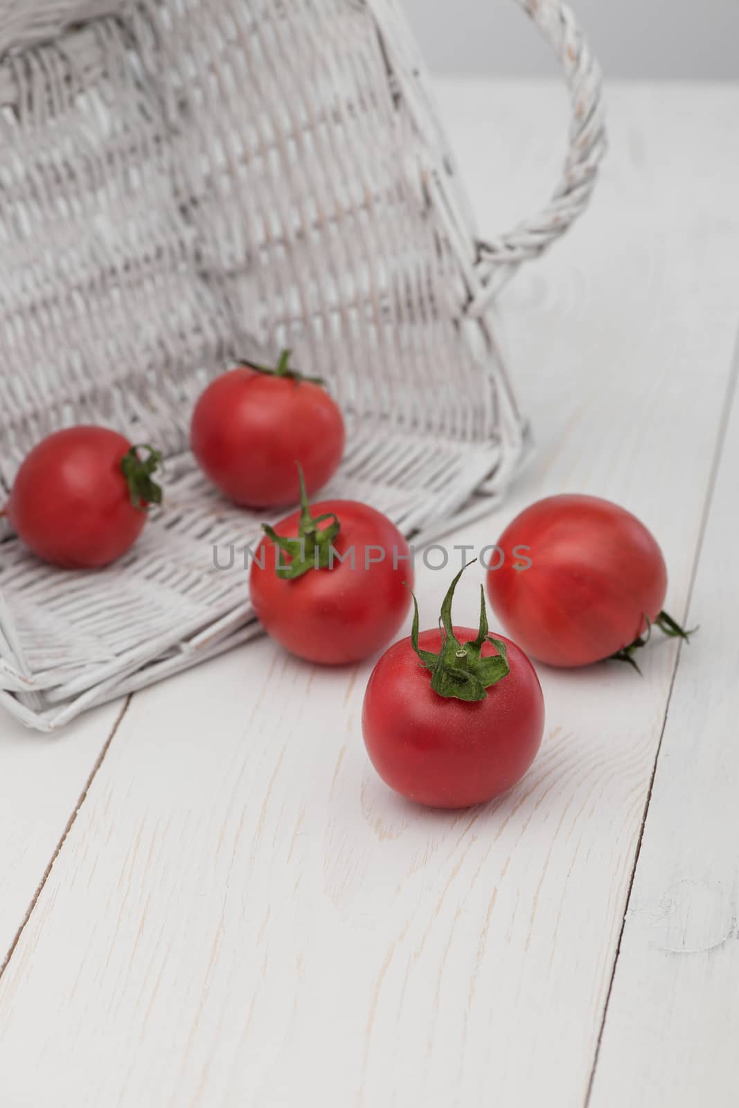 tomatoes in a white basket on a white background