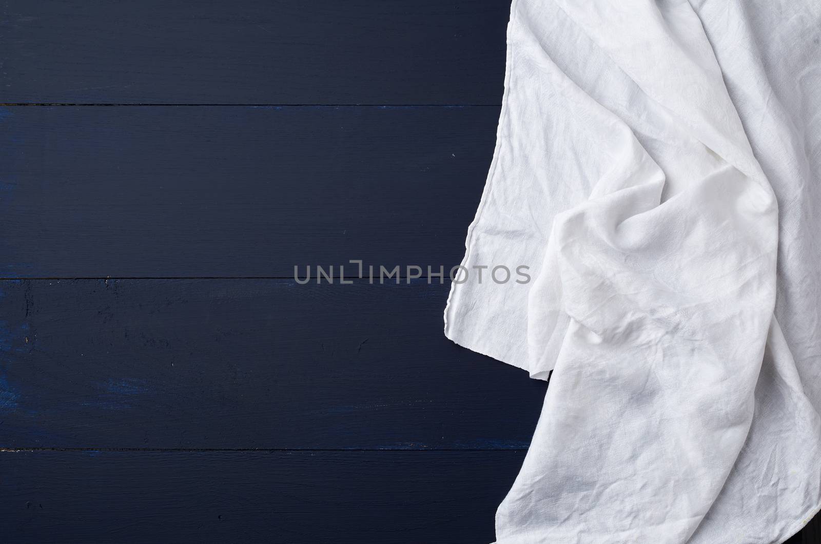 white linen towel on blue wooden background, top view, copy space