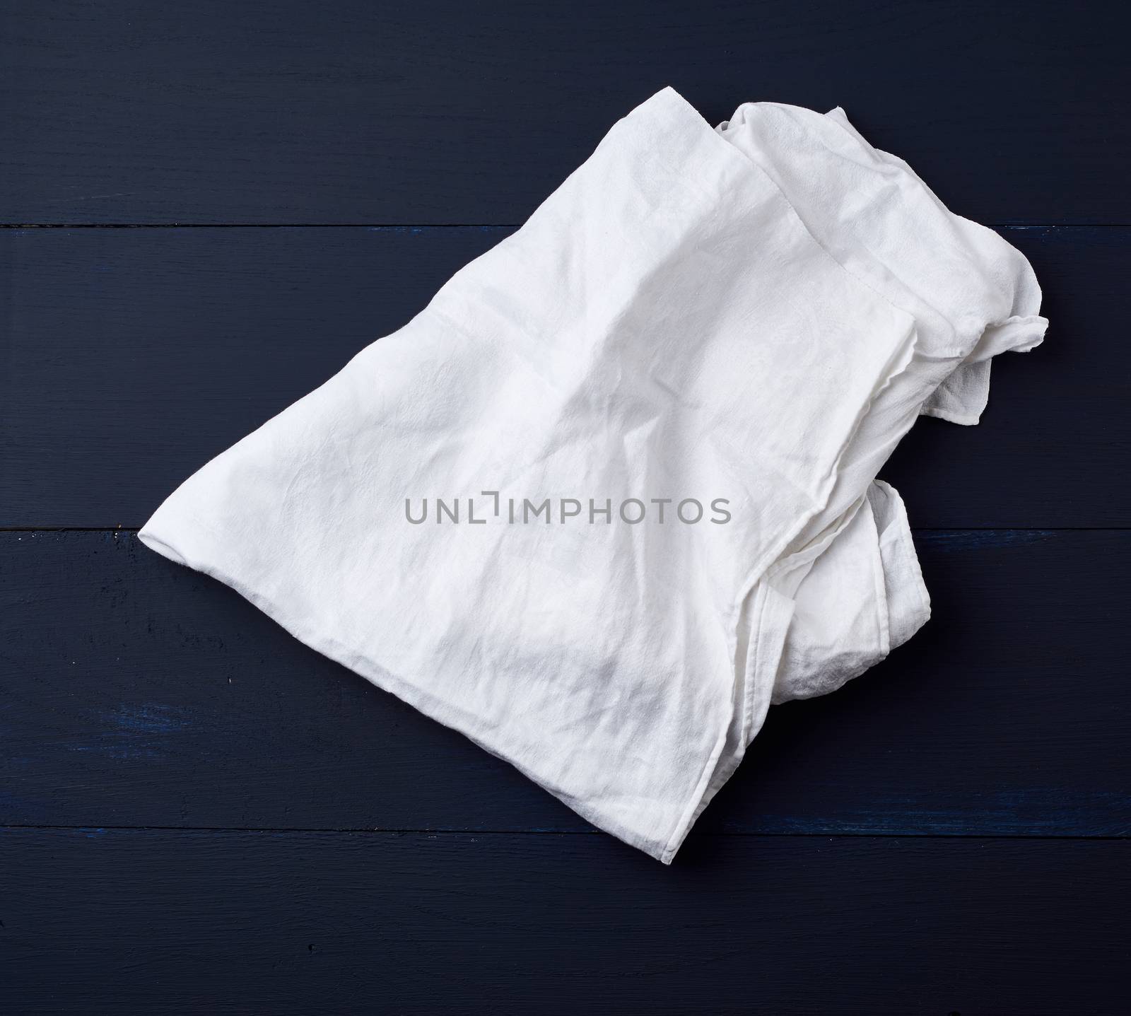 white linen towel on blue wooden background, top view, copy space