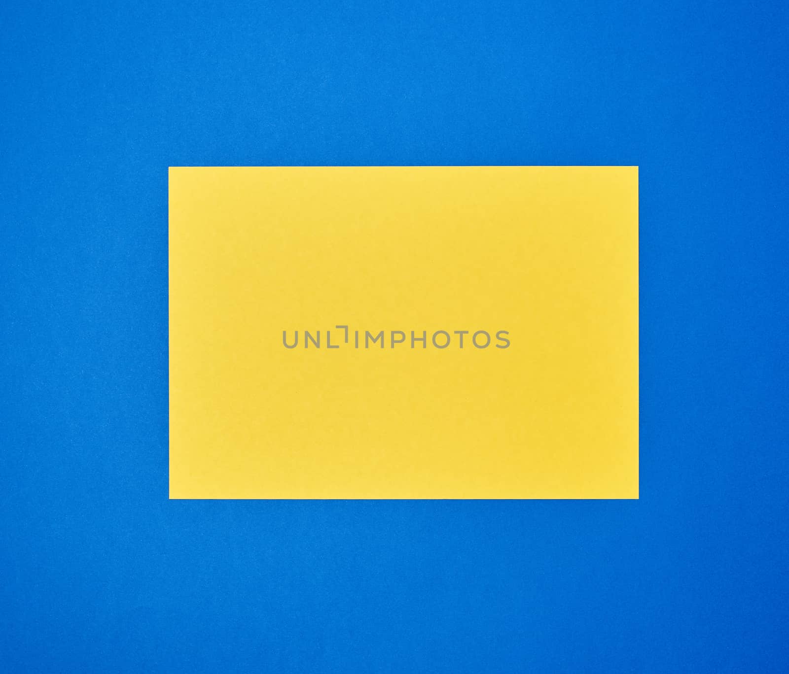 blank yellow sheet of A4 paper on a blue background. Business template. Copy space