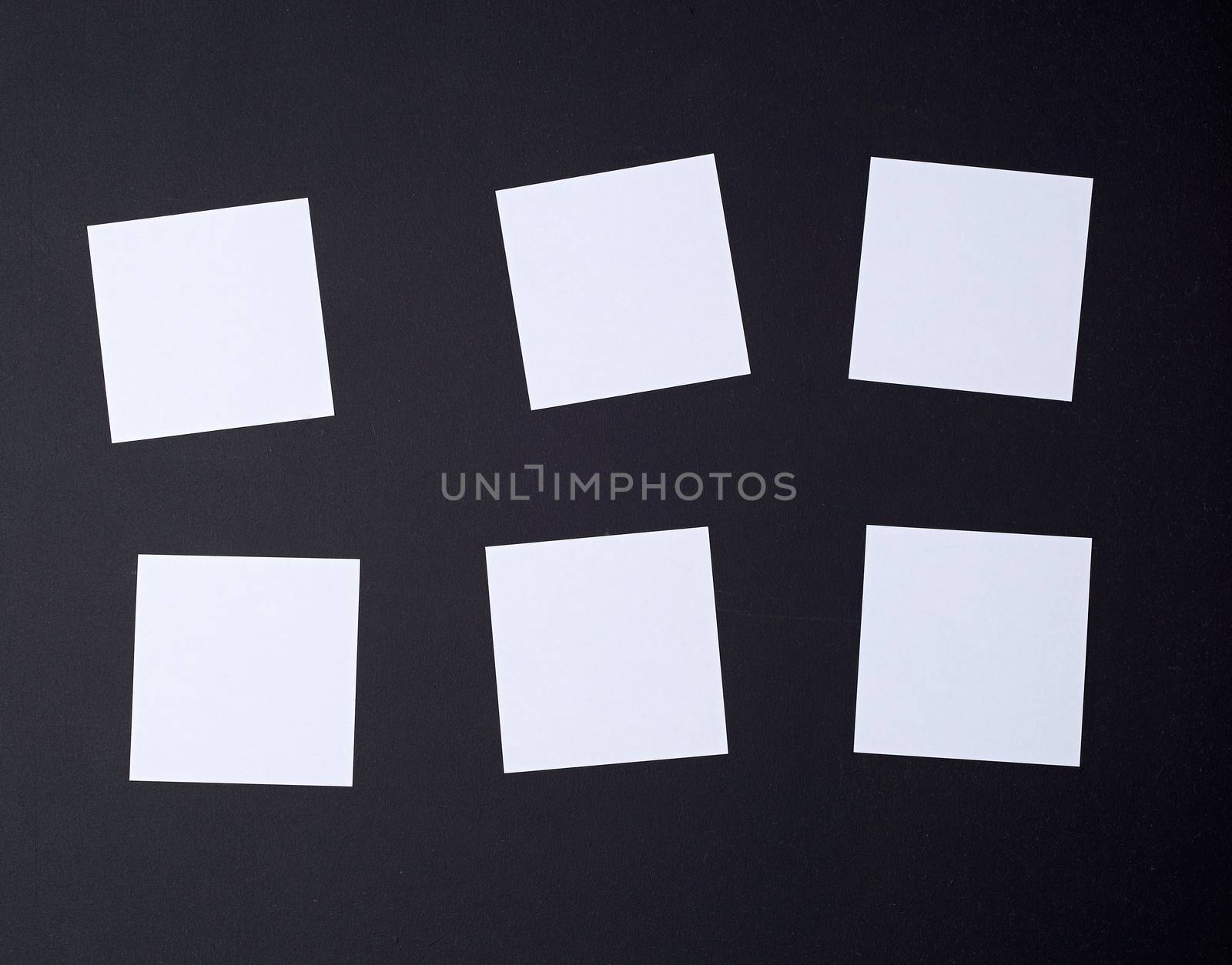 empty white small square sheets of paper on a black background. Mockup template. Business background.