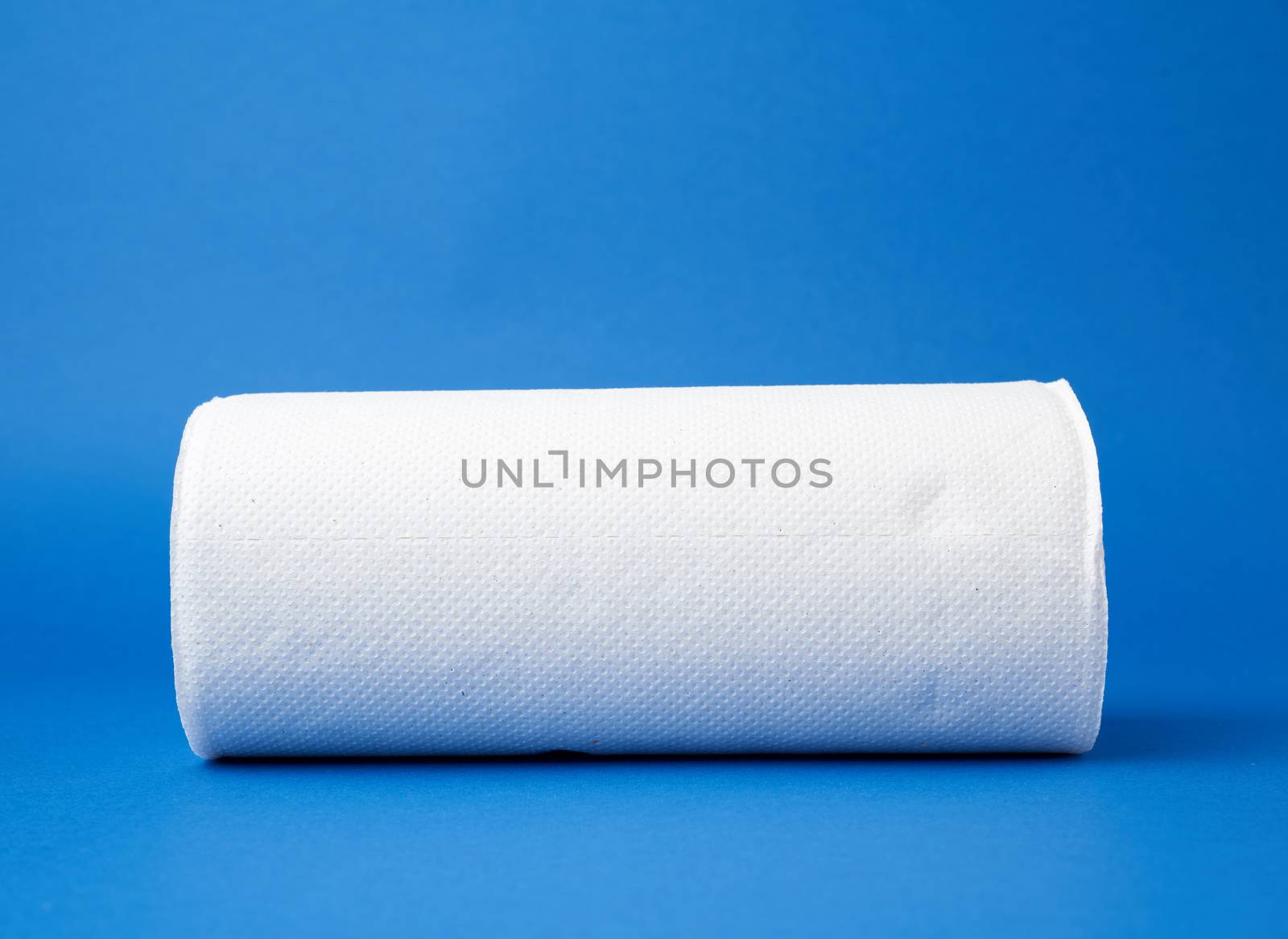 twisted roll of white paper towel on a blue background. Paper sheet. Household equipment. White napkin.