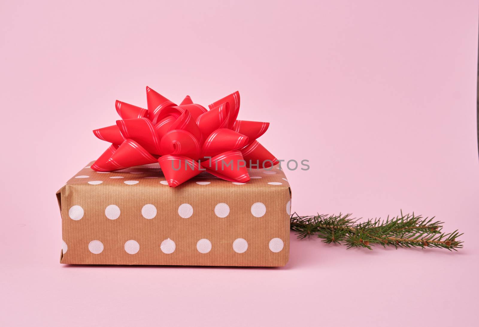 stack of kraft paper wrapped gifts, spruce branch. Christmas greeting concept.