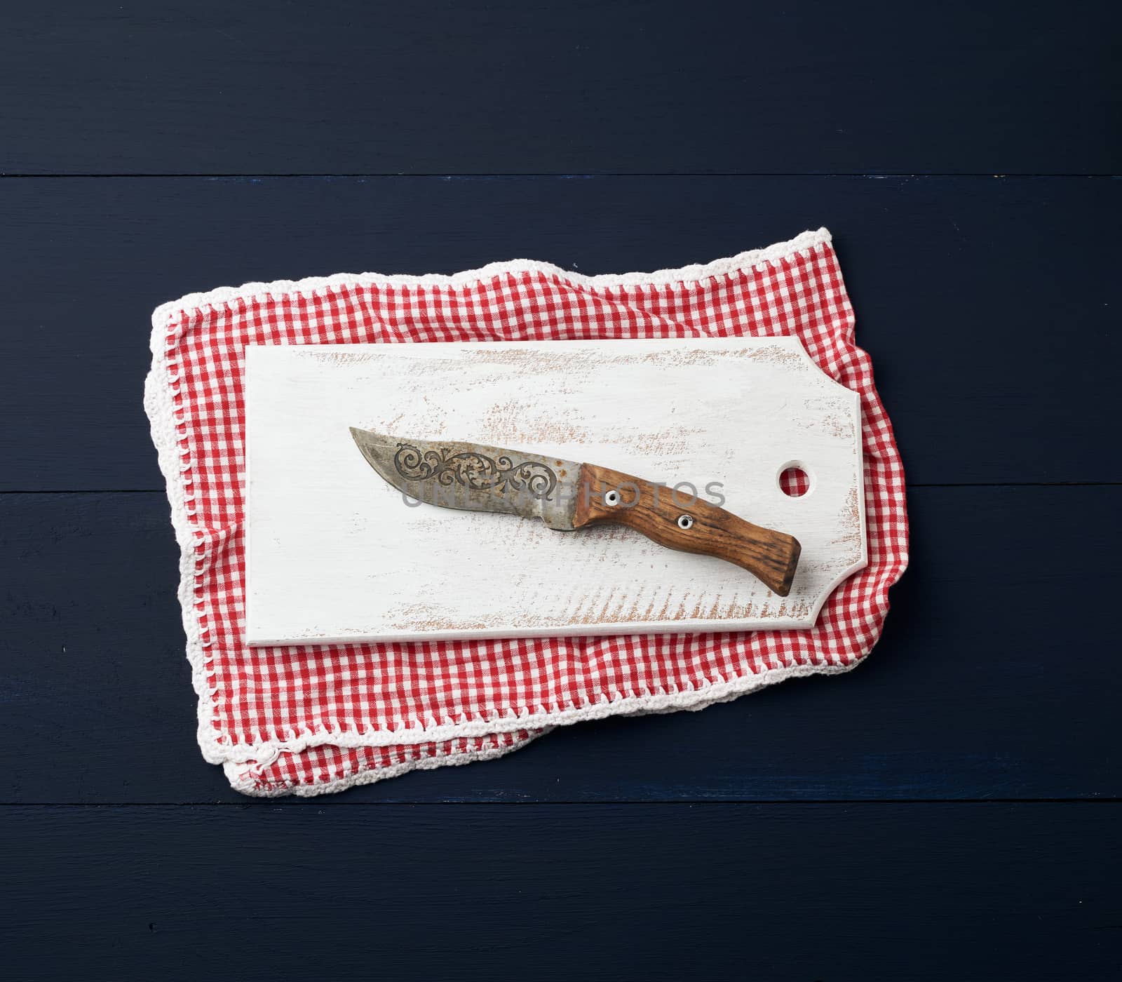 empty white wooden rectangular cutting board and knife, top view, blue wooden background 