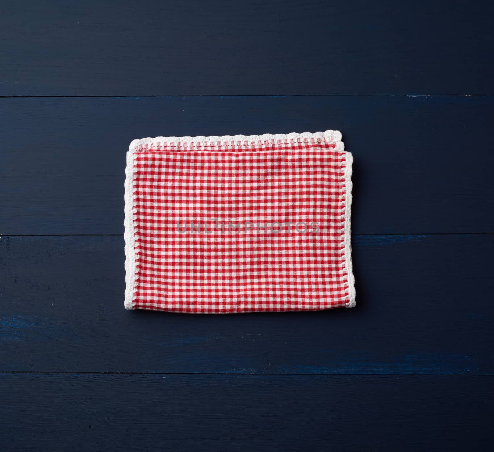 white red checkered kitchen towel on a blue wooden background, picnic background, copy space