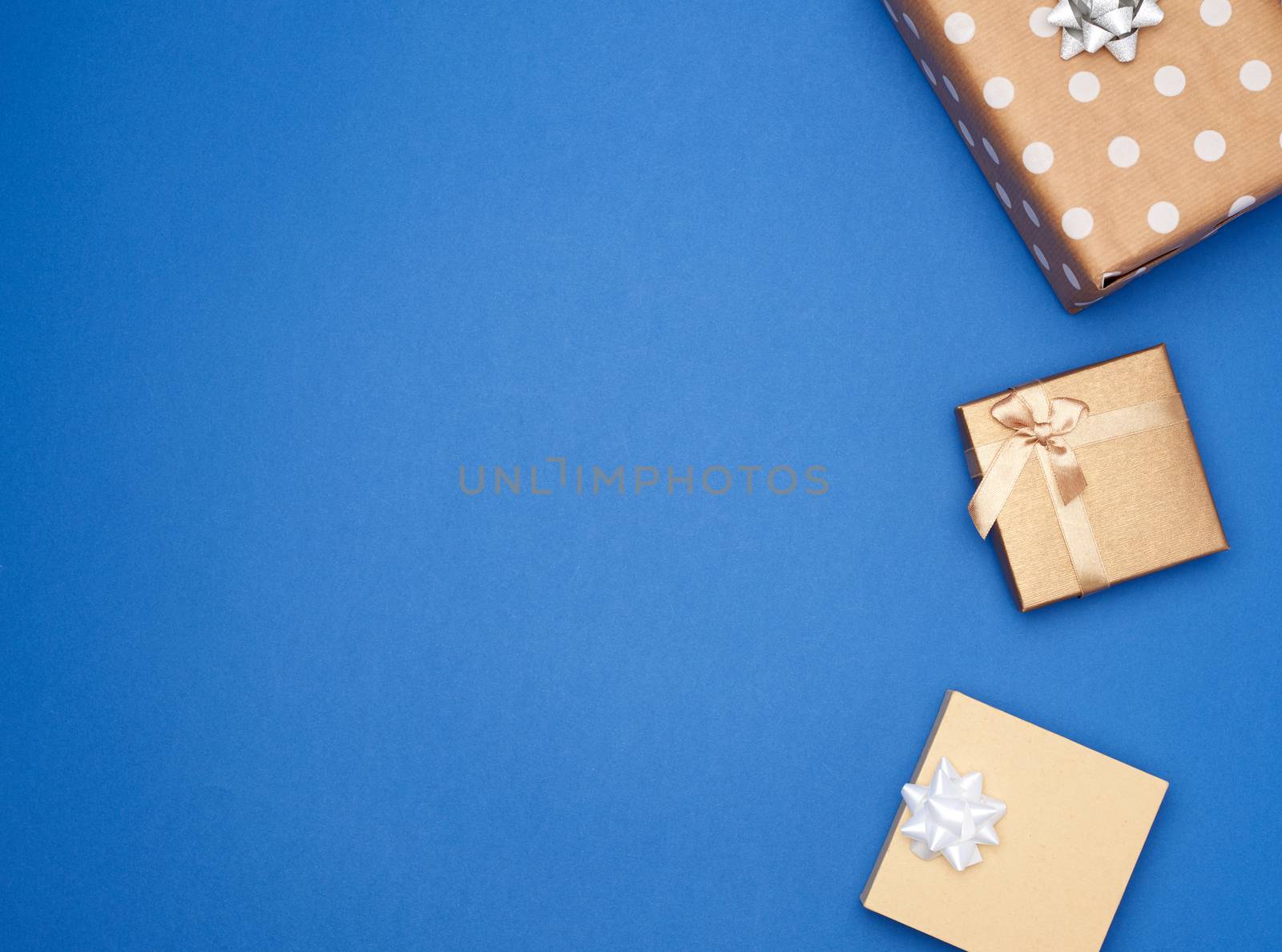square brown box with white bow on a blue background, top view, empty place for an inscription