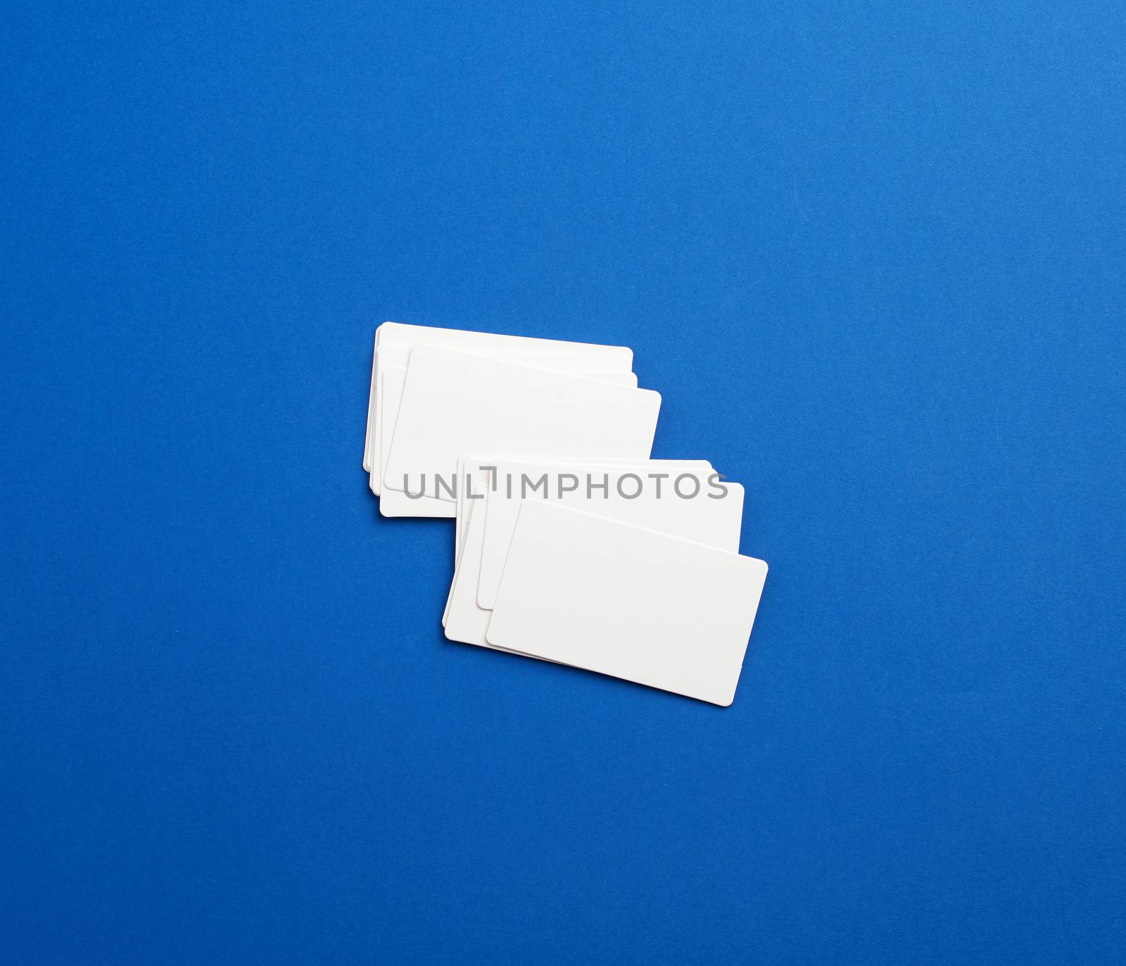 stack of rectangular white blank business cards on a blue background. Corporate business concept