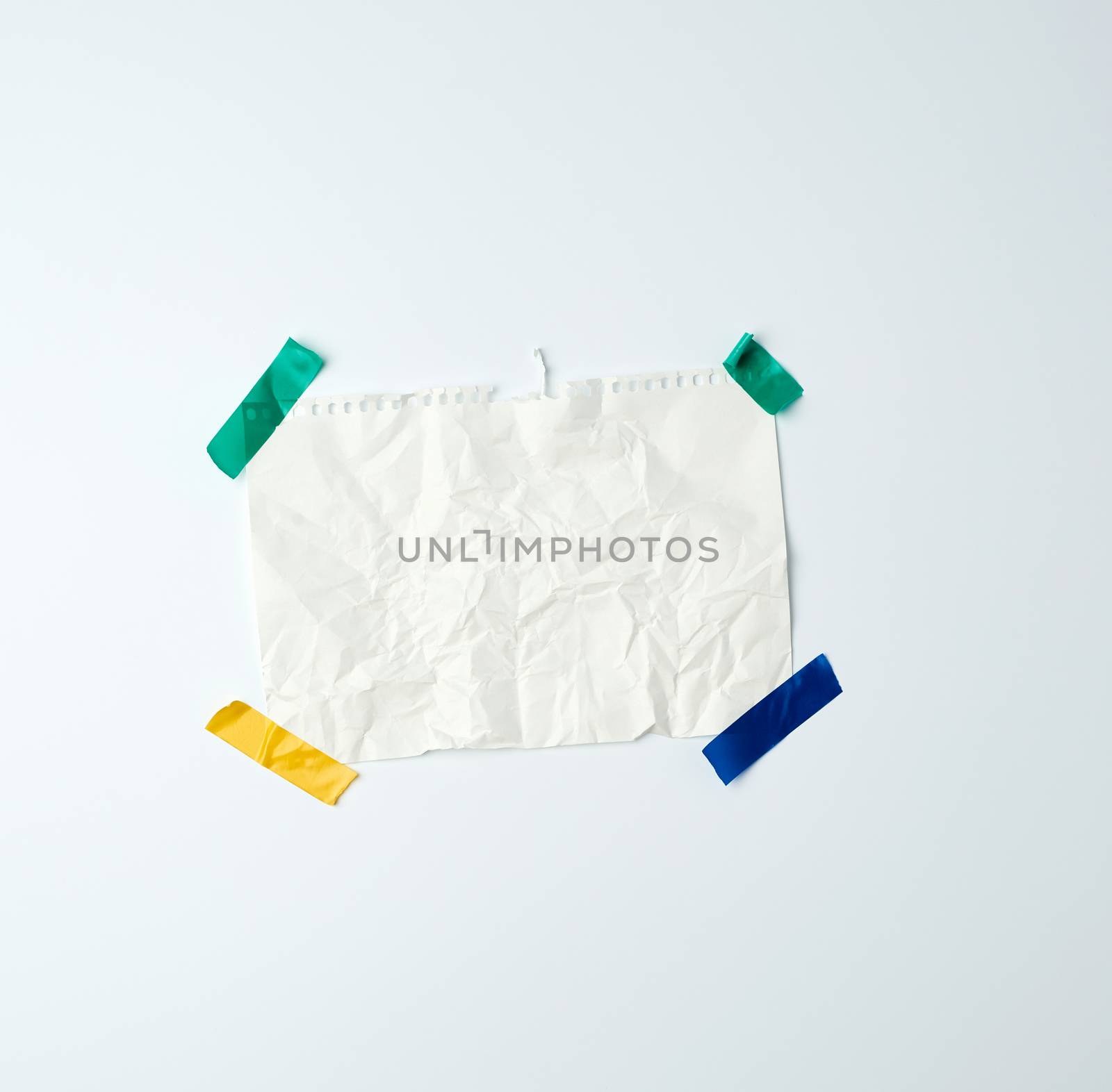 white crumpled sheet of paper torn from a spiral notebook and glued with multi-colored electrical tape on a white background, place for text