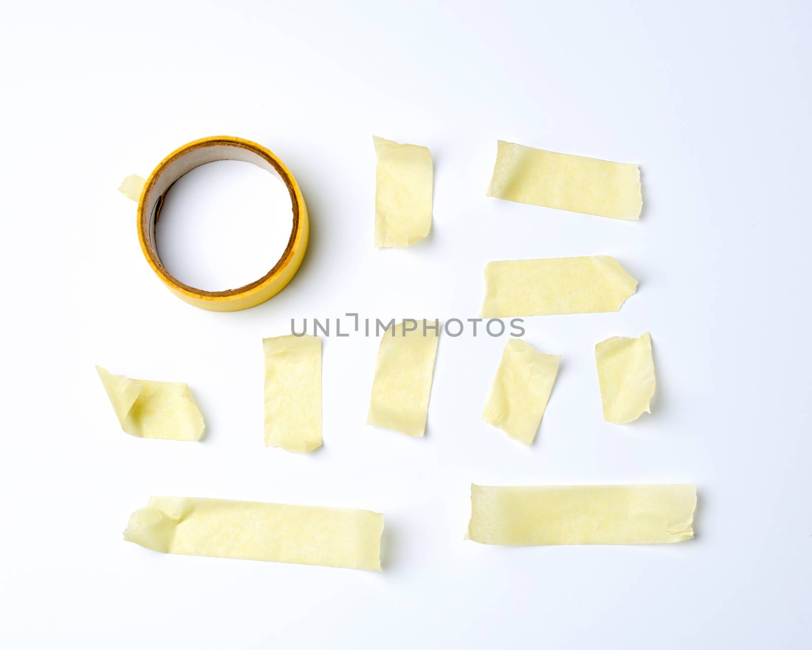 set of various pieces of yellow sticky paper tape on a white background, close up