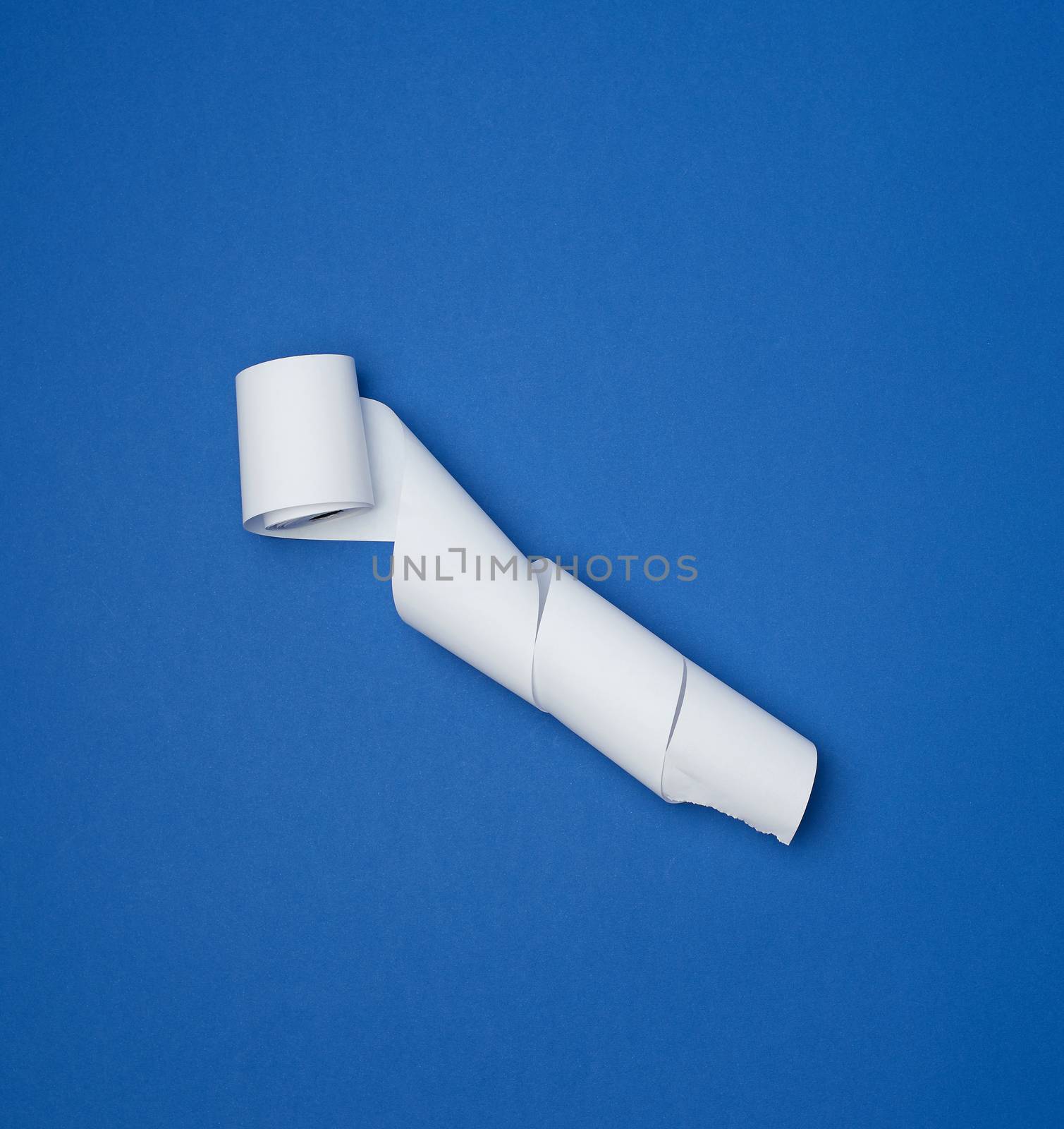 twisted white ribbon for cash register on a blue background, top view