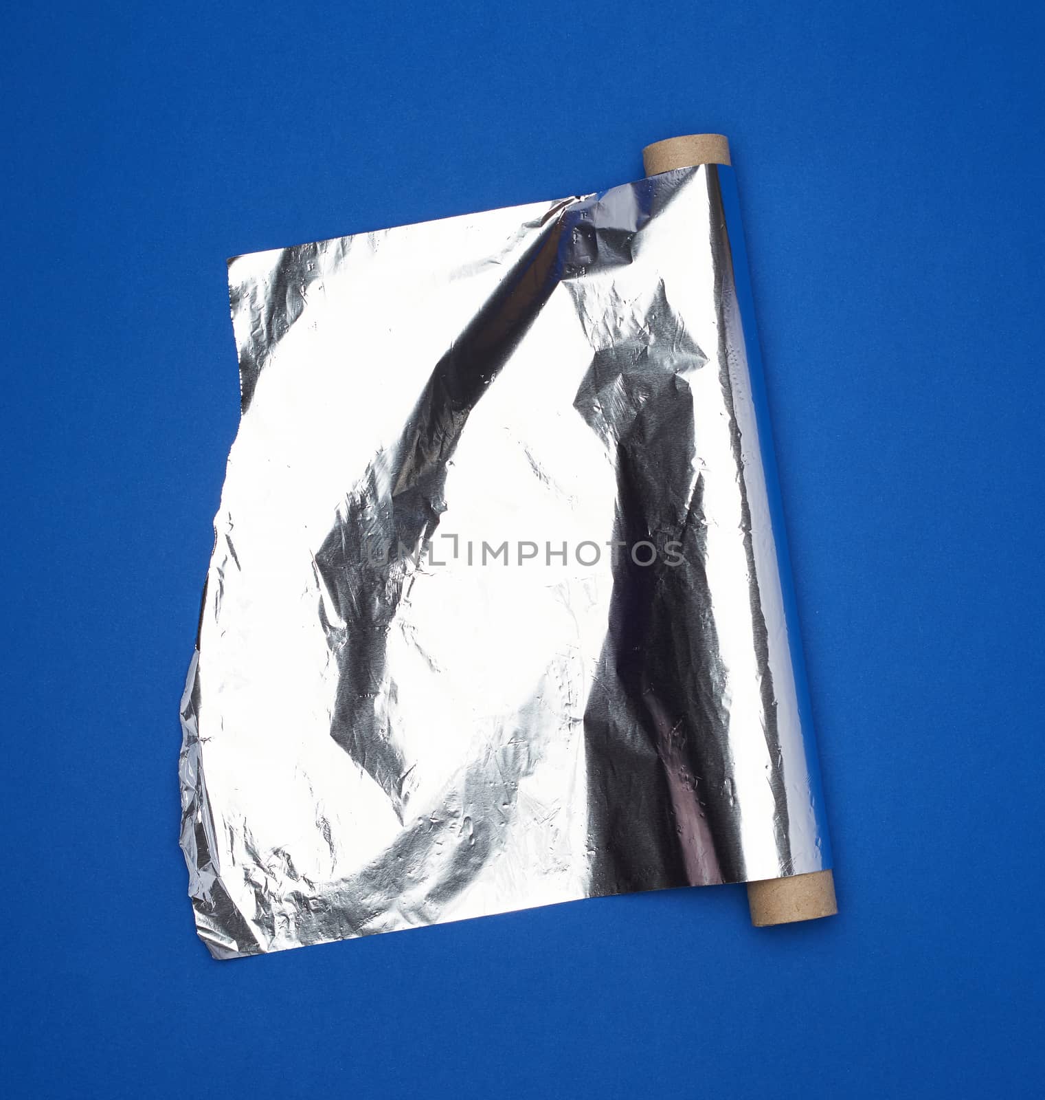roll of gray foil for baking and packaging food on a dark blue background, torn edge