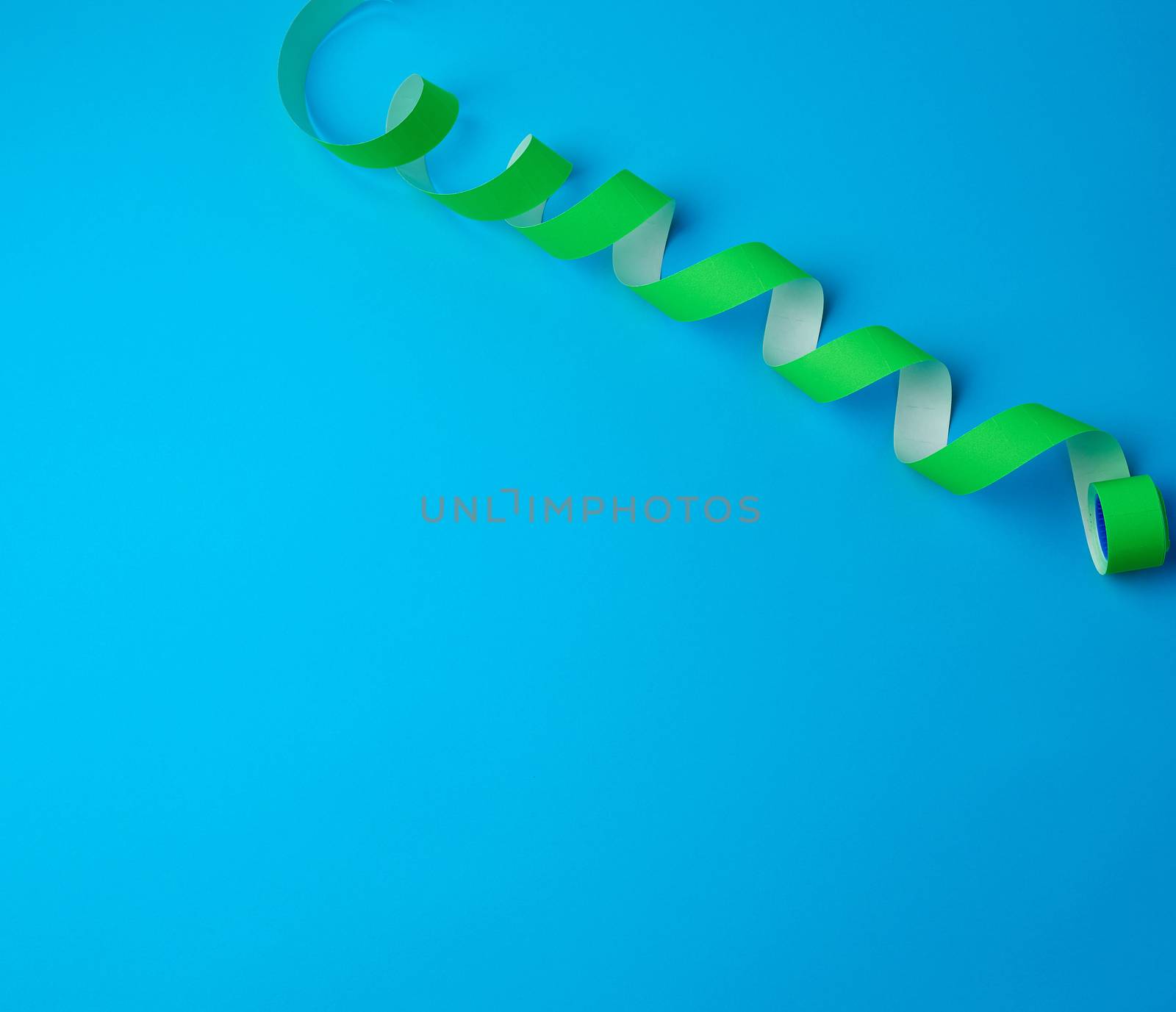 untwisted reel with green sticky stickers on a blue background, top view