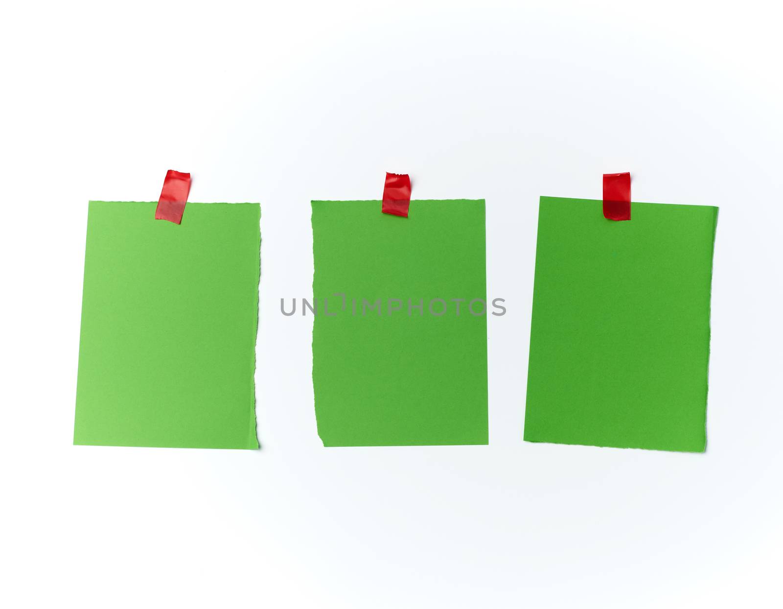 lot of torn green pieces of paper glued with scotch tape on a white background, place for text