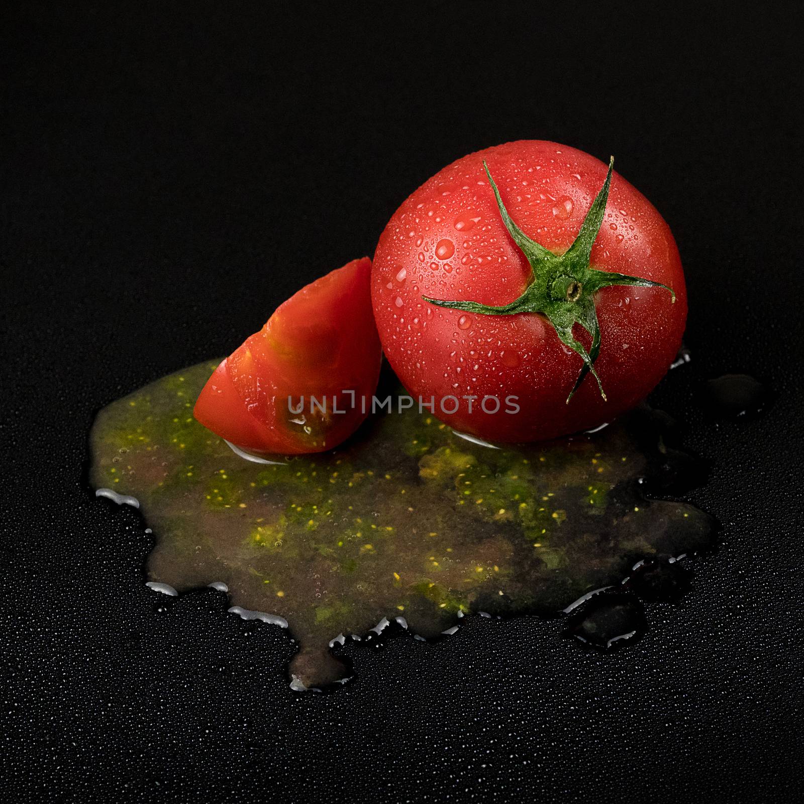 fresh wet tomatoes on a black background. sliced tomatoes with pulp
