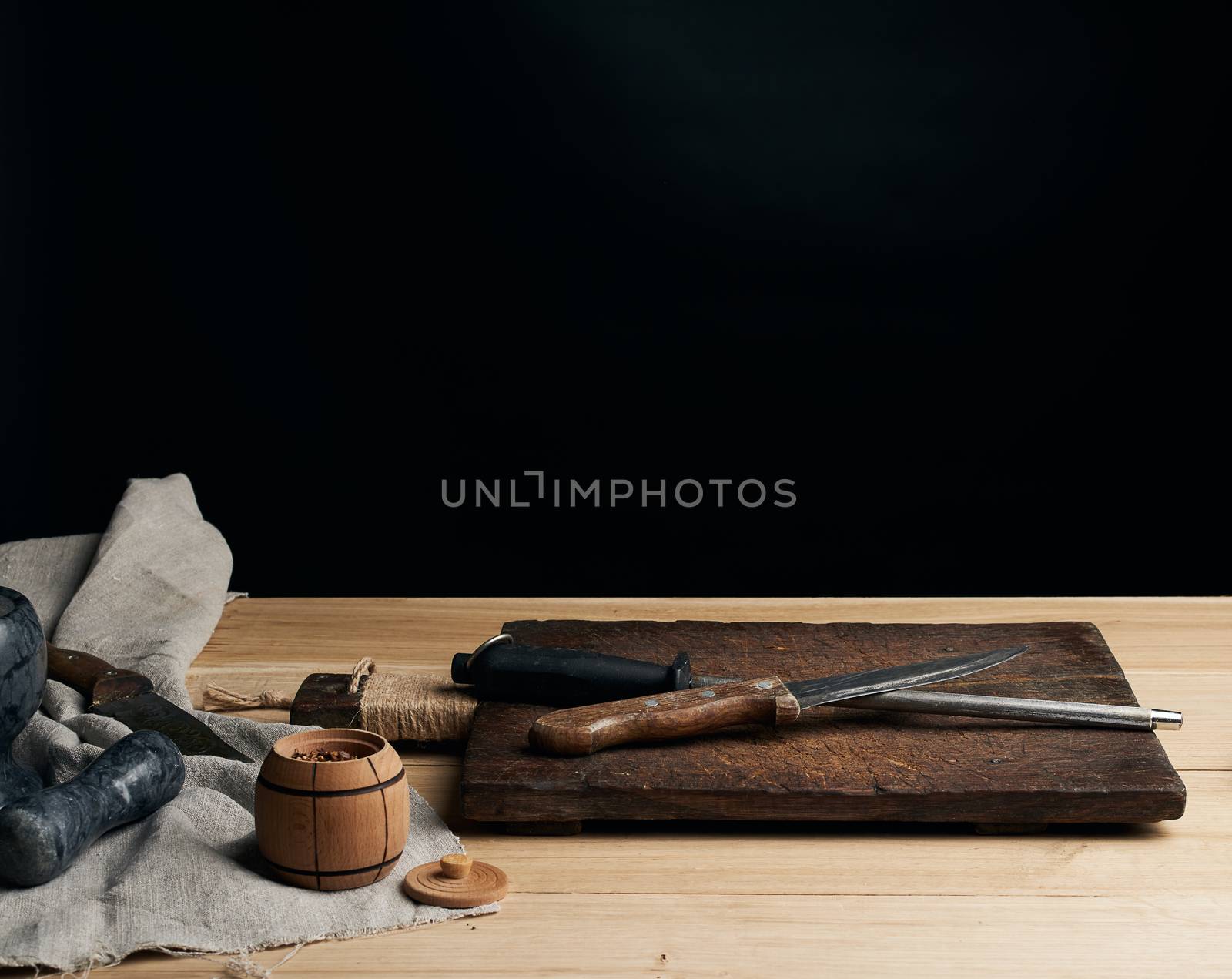 old sharp knife and sharpener with a handle on a wooden background, copy space
