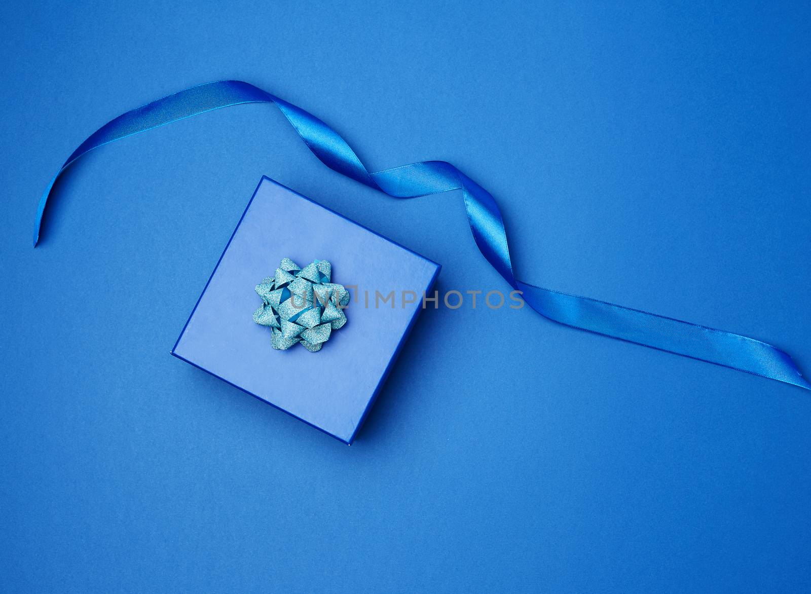 cardboard gift square box, bows, ribbons for packaging on a dark blue background, top view, trend colors