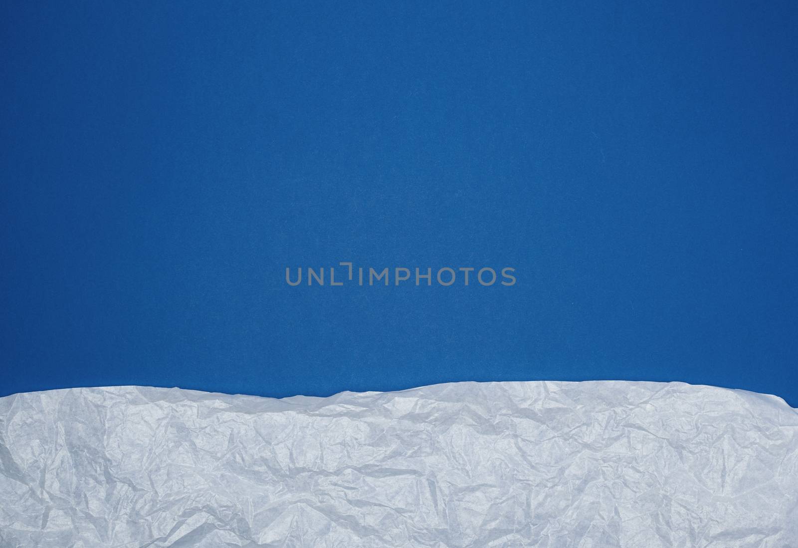 blue background with white crumpled torn paper elements, place for writing op in the middle, template