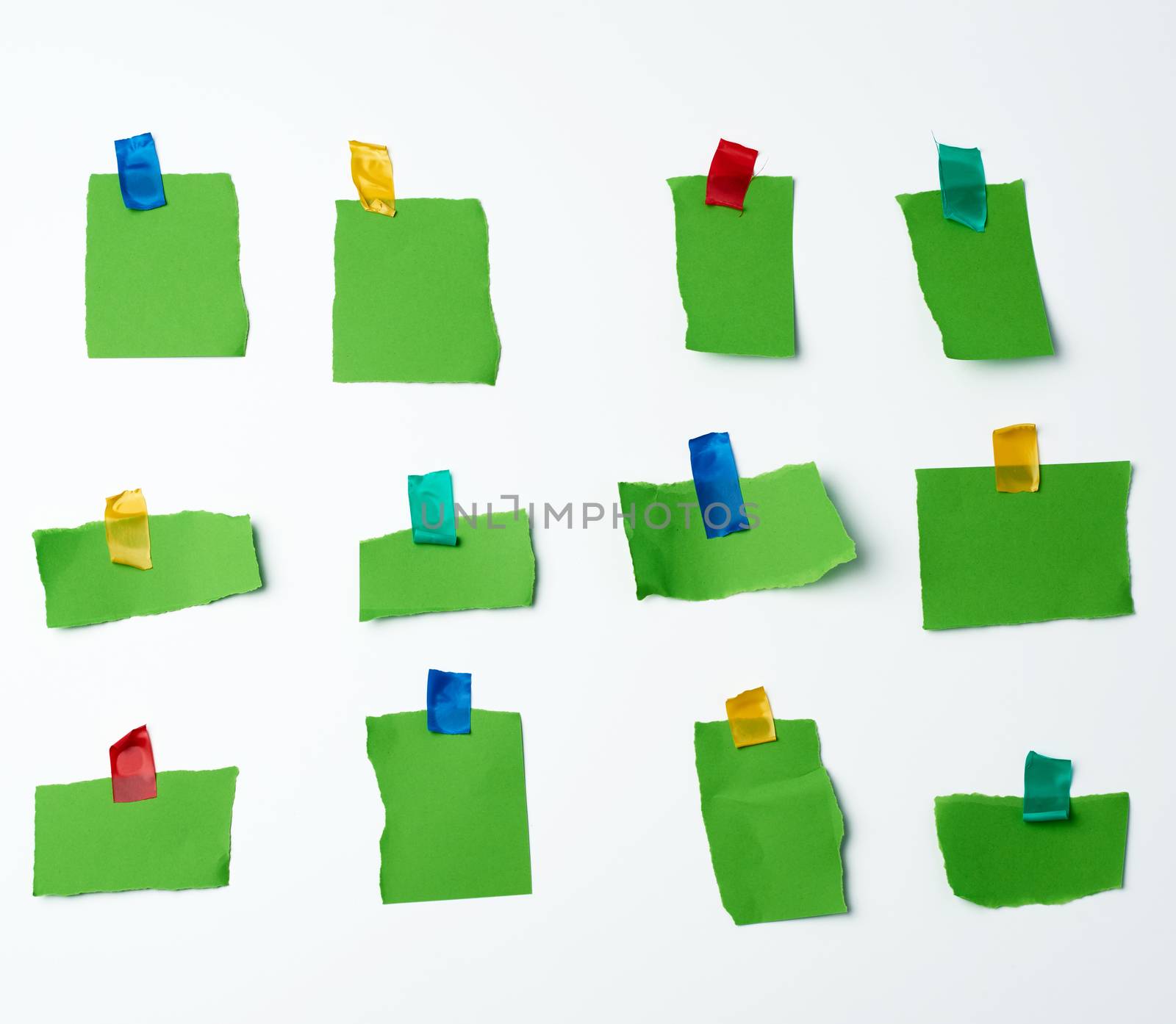 lot of torn green pieces of paper glued with scotch tape on a white background, place for text