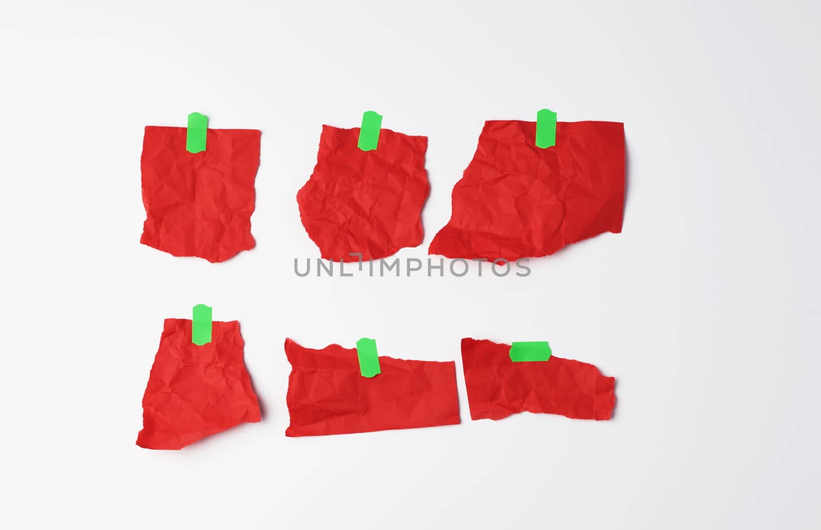 various empty red pieces of paper stuck with green velcro on a white background, place for text