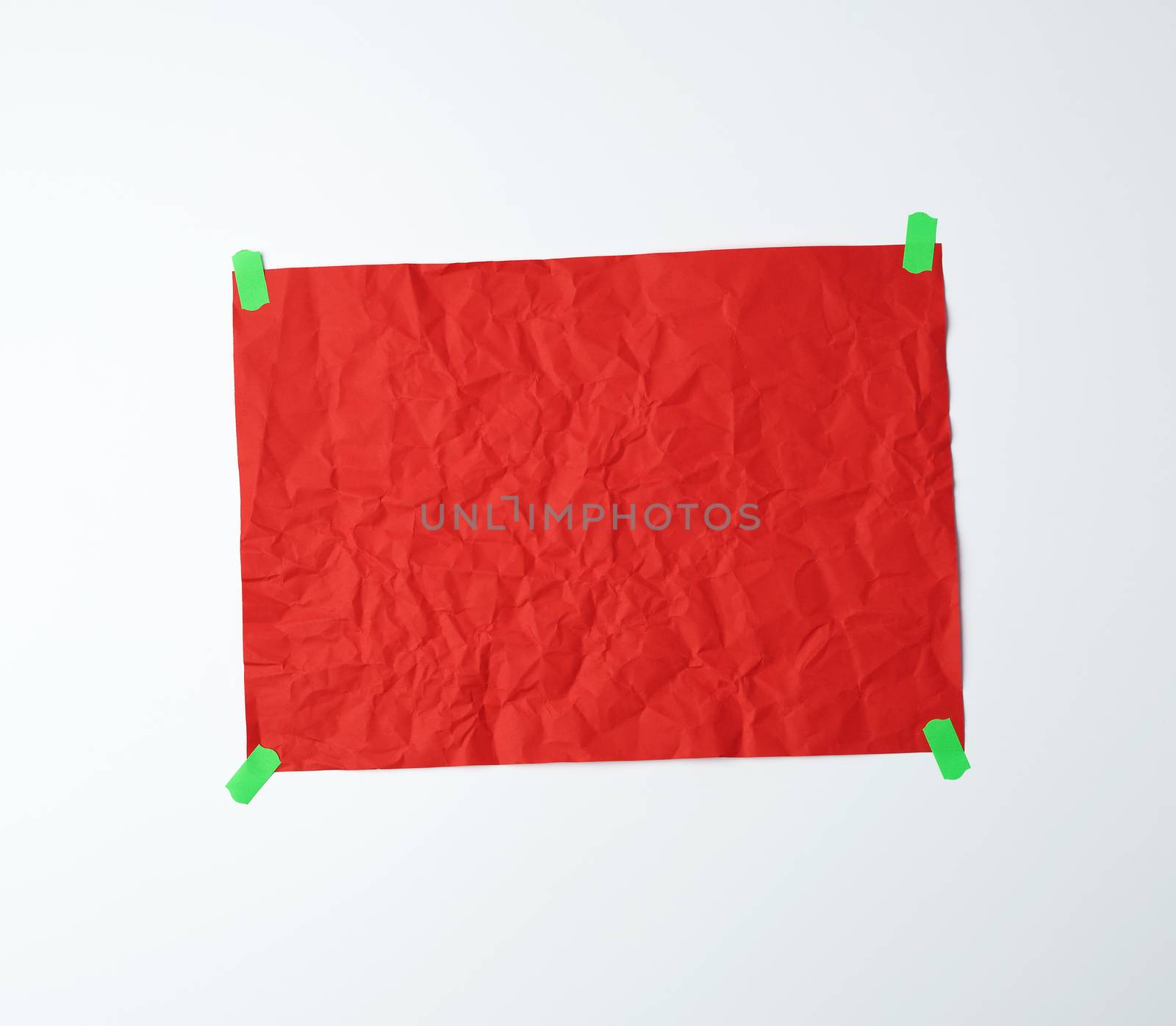 blank red crumpled sheet of paper glued with green sticky pieces of paper on a white background, place for an inscription