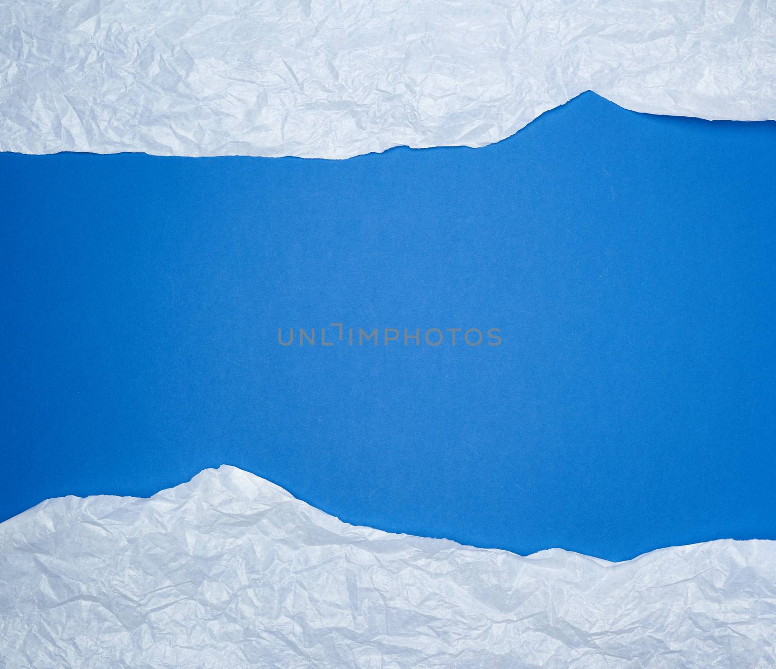 blue background with white crumpled torn paper elements, place for writing op in the middle, template