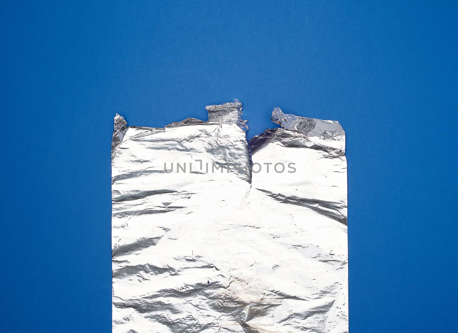 gray foil for baking and packaging food on a blue background, torn edge