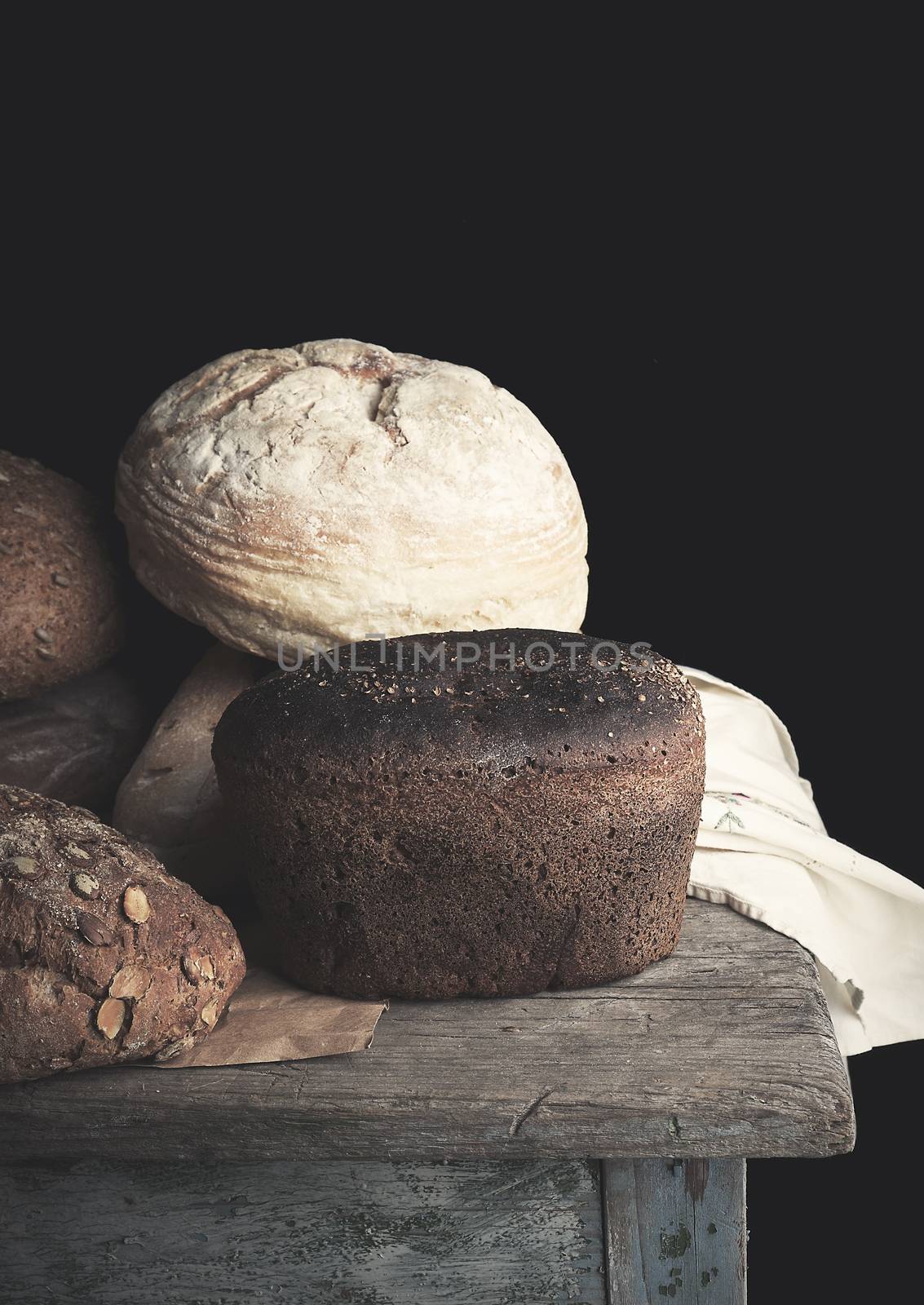 various baked rolls of rye bread on a wooden surface, vintage toning, close up